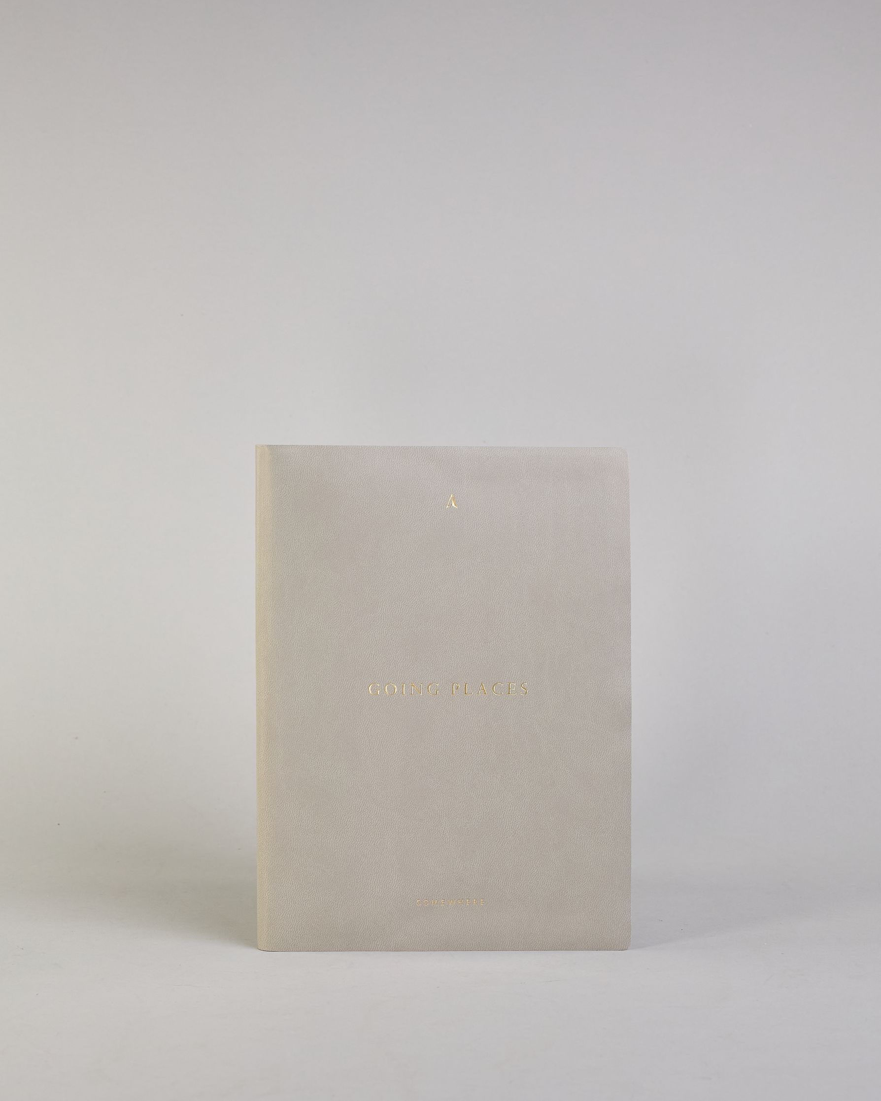 Hellgraues PU-Notizbuch mit zarter goldener Aufschrift "Going Places" auf der Vorderseite. Innen ist das System aus Kraftpapier und es können drei Hefte und ein Block flexibel eingehängt und immer wieder ausgetauscht werden. #6