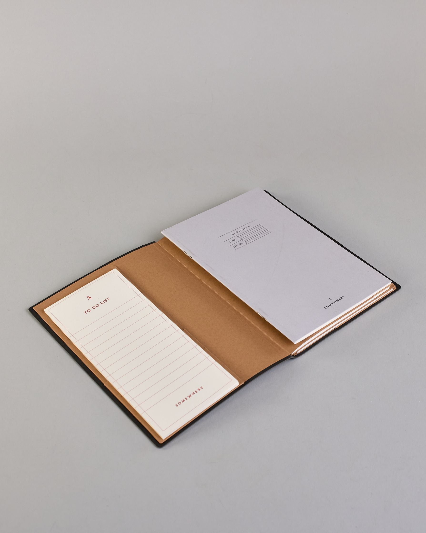 Dunkelgraue PU-Notizbuch mit zarter goldener Aufschrift "Brilliant Thoughts" auf der Vorderseite. Innen ist das System aus Kraftpapier und es können drei Hefte und ein Block flexibel eingehängt und immer wieder ausgetauscht werden. #2