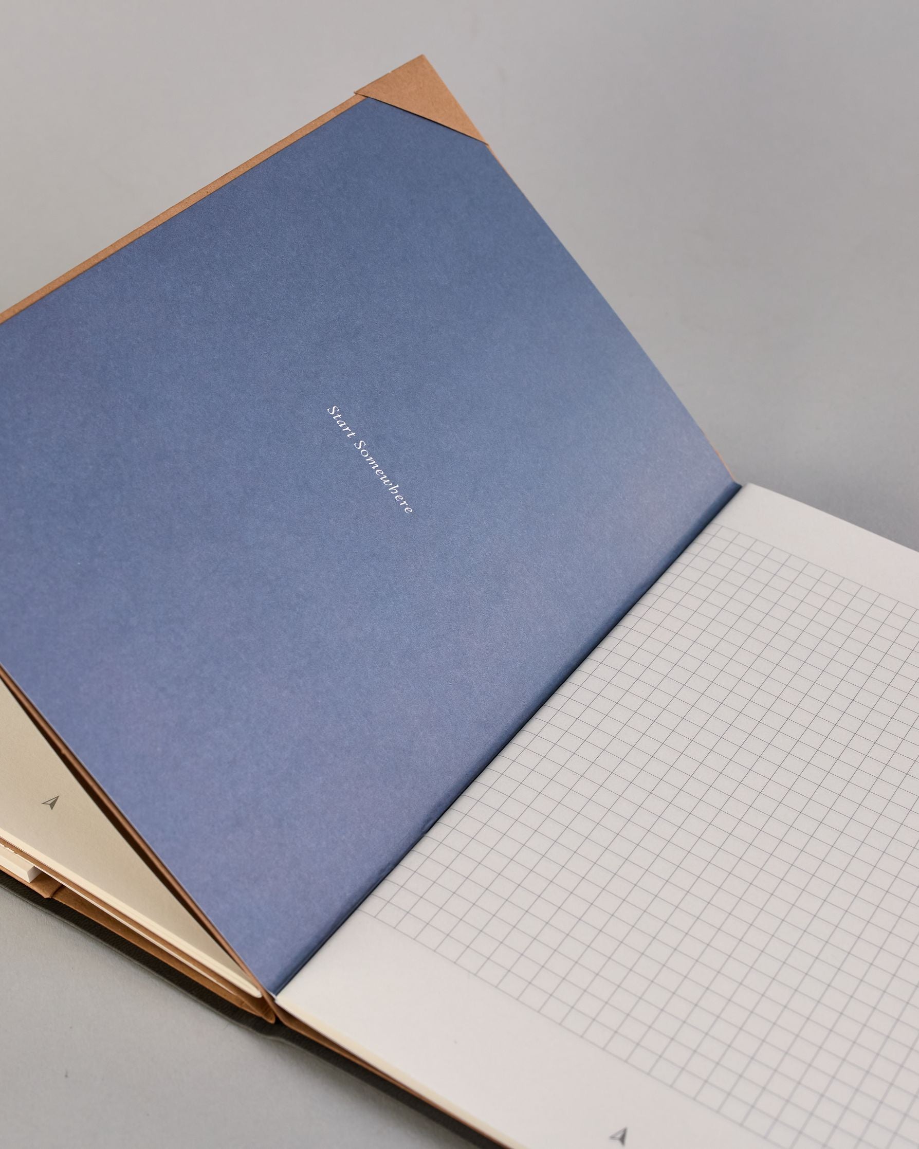 Dunkelgraue PU-Notizbuch mit zarter goldener Aufschrift "Brilliant Thoughts" auf der Vorderseite. Innen ist das System aus Kraftpapier und es können drei Hefte und ein Block flexibel eingehängt und immer wieder ausgetauscht werden. #4