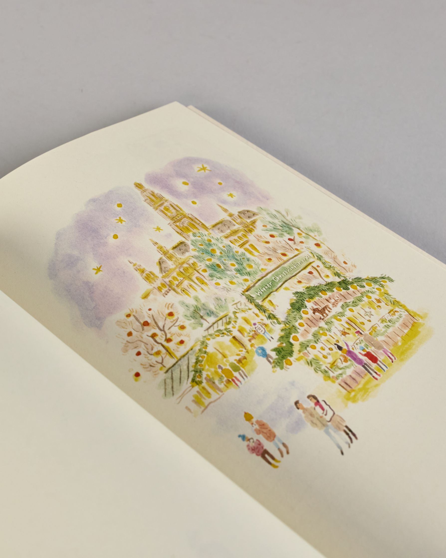 Notizbuch mit cremefarbenem Einband, darauf eine zarte Illustration der Wiener Staatsoper mit vorbeifahrender Straßenbahn und kleinen Figuren im Vordergrund. Titel: ‚Vienna – le journal de l’après-midi. Innen ist jede Seite individuell illustriert. #6