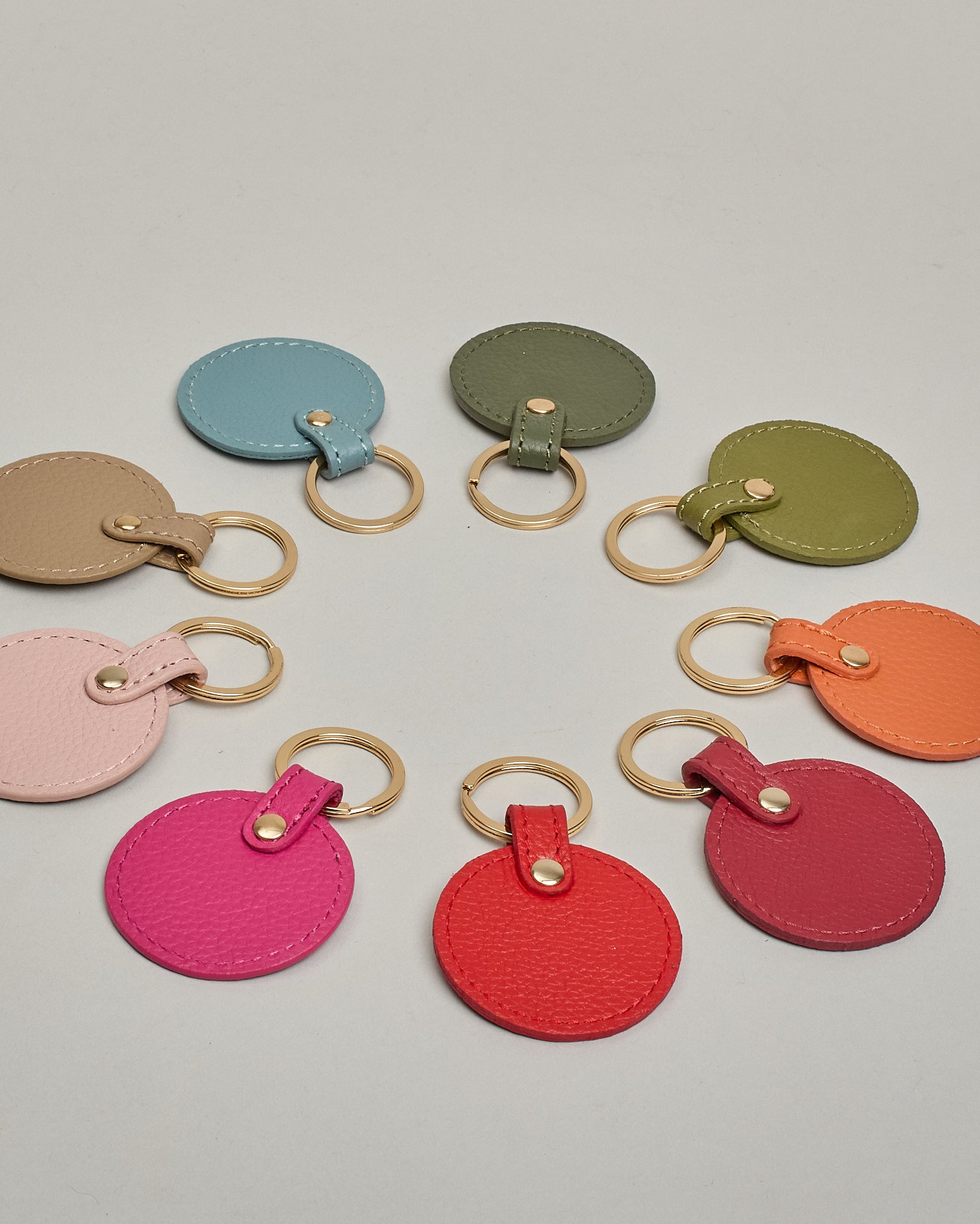 Schlüsselanhänger in Kreisform aus echtem Rindsleder. Das Leder ist orange, der Ring mit dem man das Lederaccessoire an dem Schlüssel befestigen kann ist gold. Auf der Rückseite ist die das Logo "Herzilein Wien" eingeprägt. Die Vorderseite kann personalisiert werden.