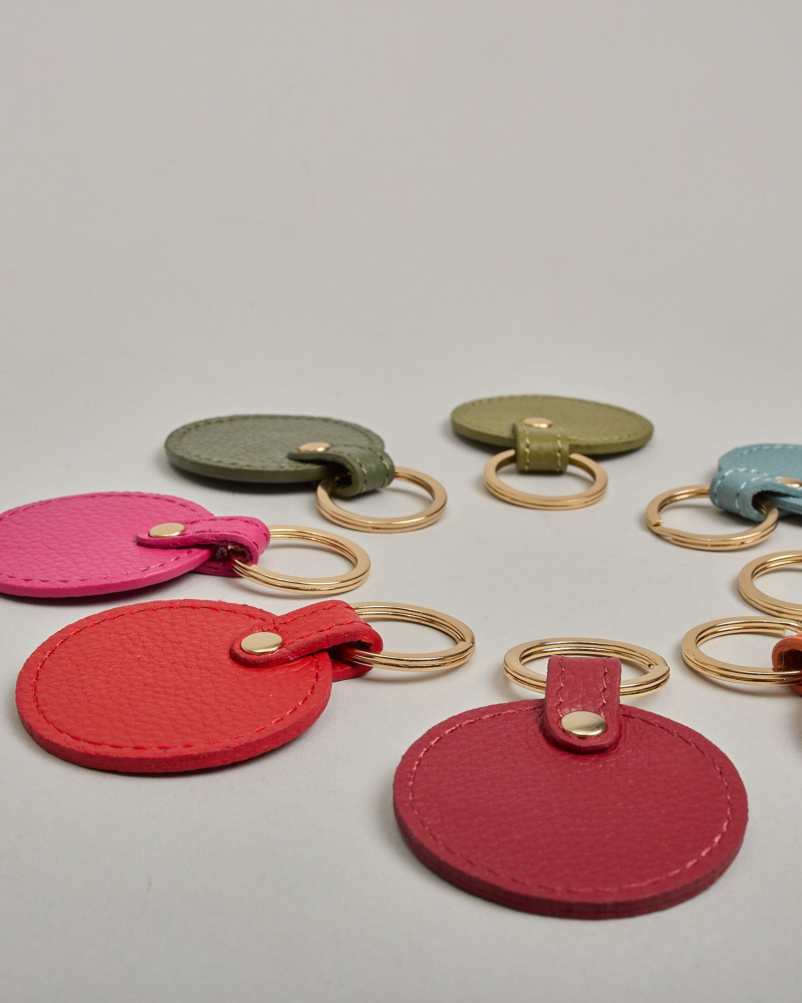 Schlüsselanhänger in Kreisform aus echtem Rindsleder. Das Leder ist orange, der Ring mit dem man das Lederaccessoire an dem Schlüssel befestigen kann ist gold. Auf der Rückseite ist die das Logo "Herzilein Wien" eingeprägt. Die Vorderseite kann personalisiert werden.