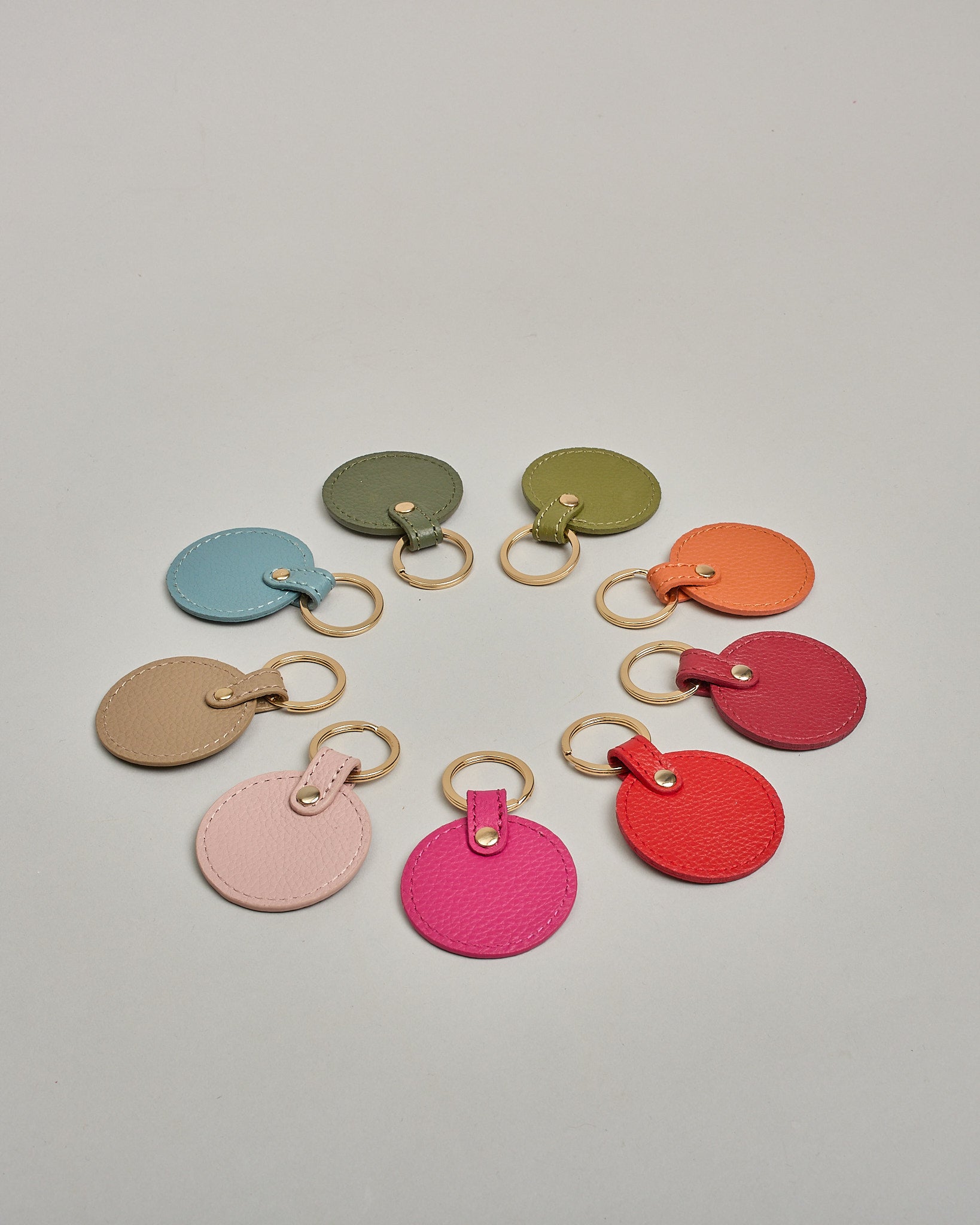 Schlüsselanhänger in Kreisform aus echtem Rindsleder. Das Leder ist orange, der Ring mit dem man das Lederaccessoire an dem Schlüssel befestigen kann ist gold. Auf der Rückseite ist die das Logo "Herzilein Wien" eingeprägt. Die Vorderseite kann personalisiert werden.