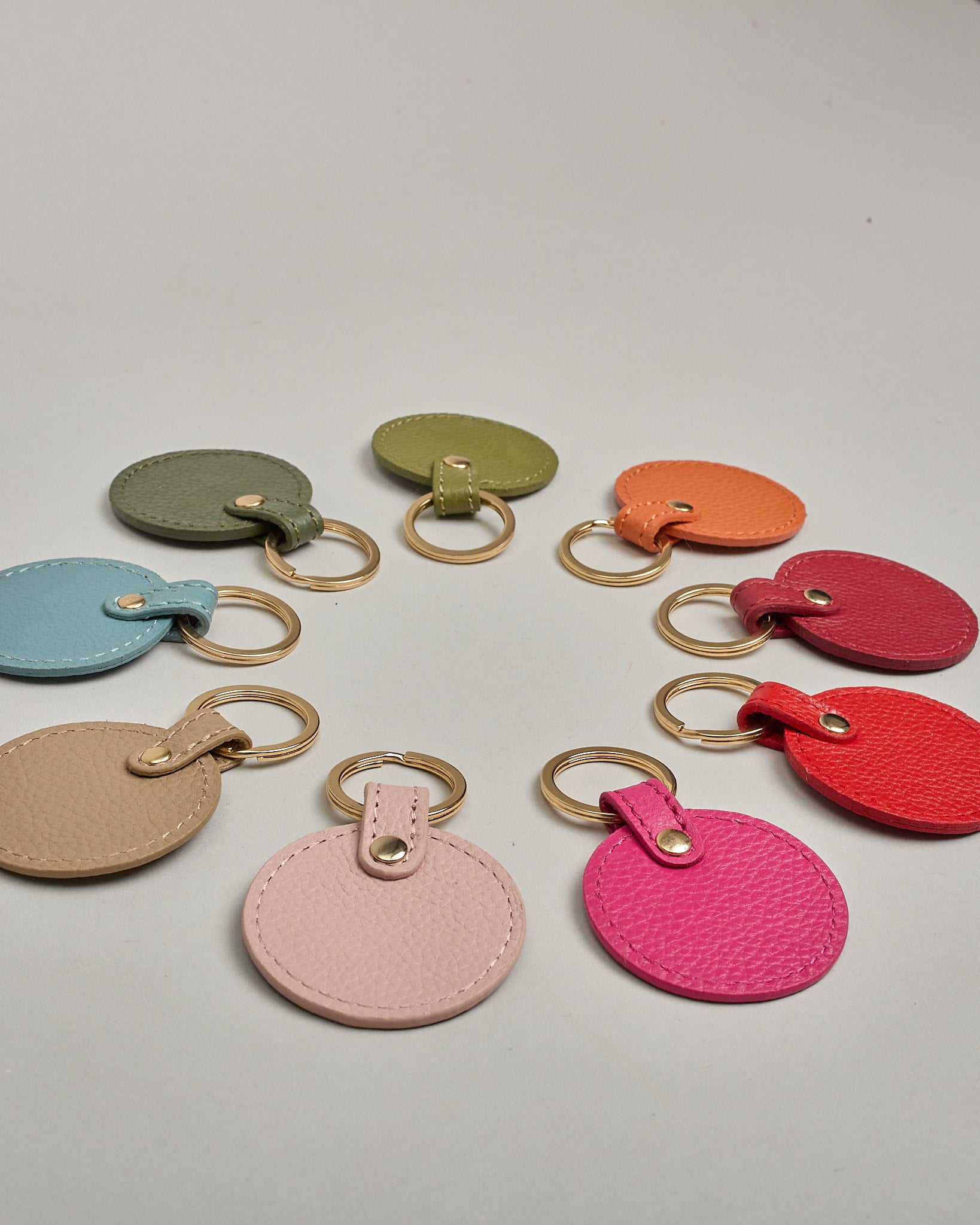 Schlüsselanhänger in Kreisform aus echtem Rindsleder. Das Leder ist orange, der Ring mit dem man das Lederaccessoire an dem Schlüssel befestigen kann ist gold. Auf der Rückseite ist die das Logo "Herzilein Wien" eingeprägt. Die Vorderseite kann personalisiert werden.