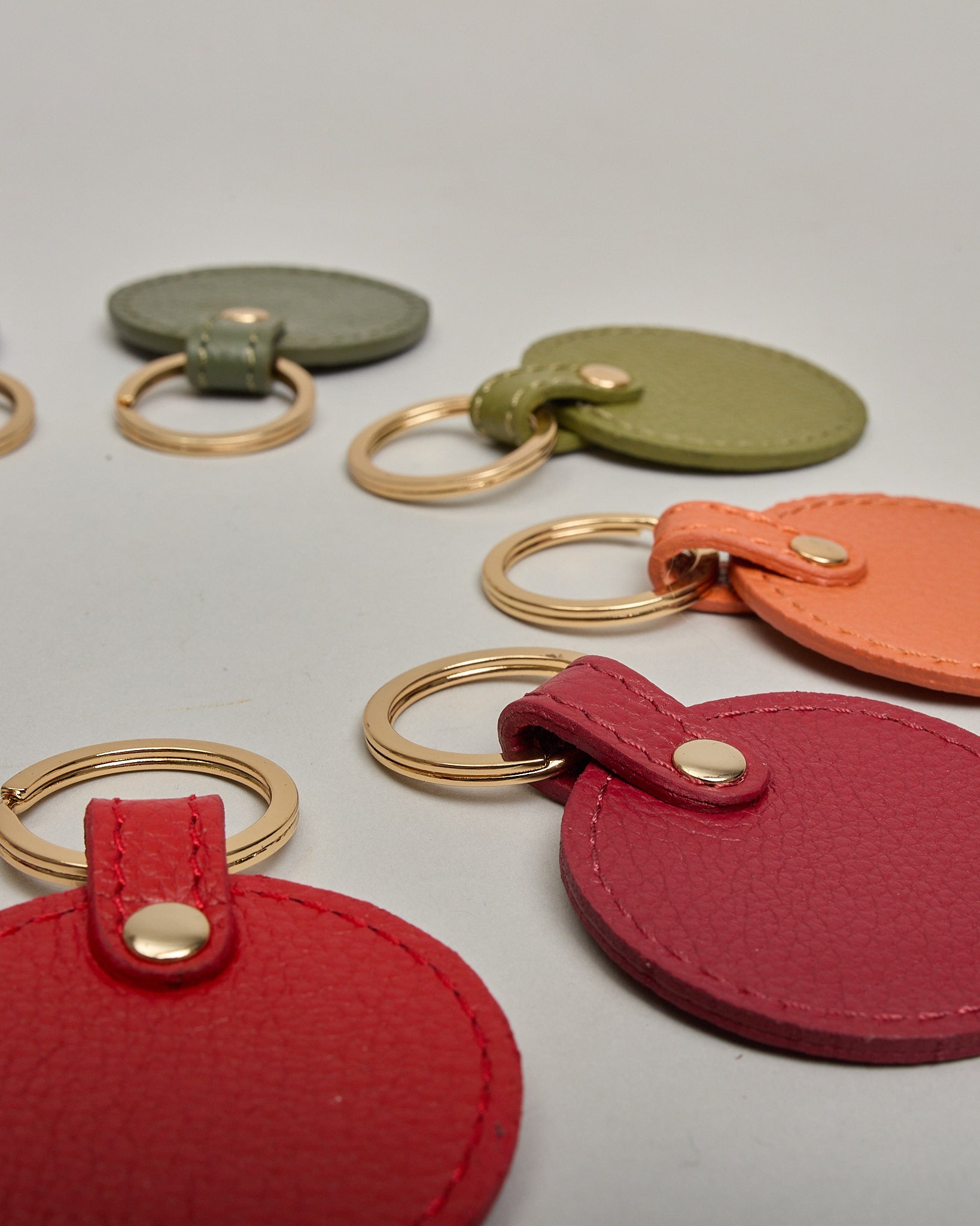 Schlüsselanhänger in Kreisform aus echtem Rindsleder. Das Leder ist orange, der Ring mit dem man das Lederaccessoire an dem Schlüssel befestigen kann ist gold. Auf der Rückseite ist die das Logo "Herzilein Wien" eingeprägt. Die Vorderseite kann personalisiert werden.