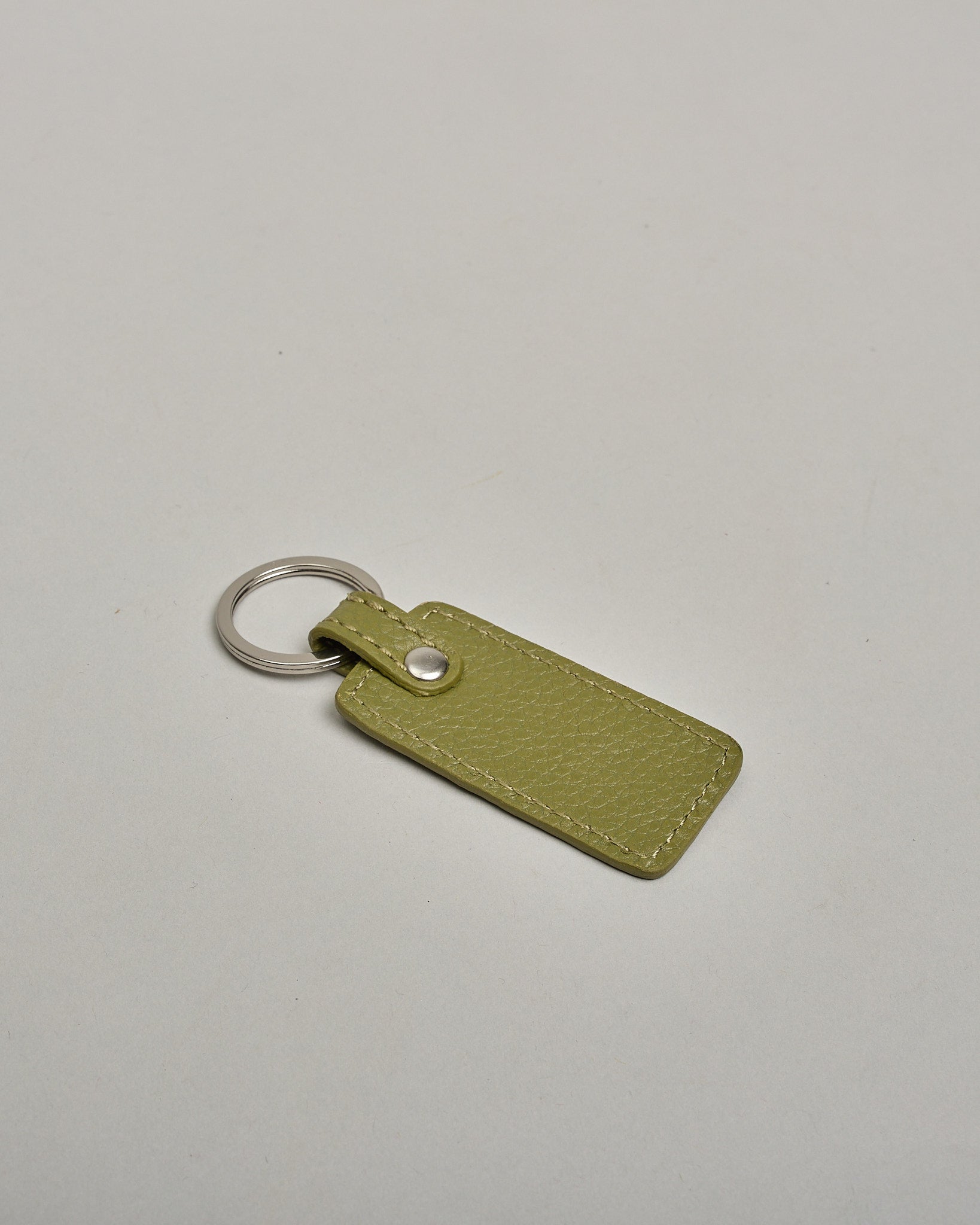 Schlüsselanhänger in Rechteckiger Form aus echtem Rindsleder. Das Leder ist dunkelgrau, der Ring mit dem man das Lederaccessoire an dem Schlüssel befestigen kann ist silber. Auf der Rückseite ist die das Logo "Herzilein Wien" eingeprägt. Die Vorderseite kann personalisiert werden