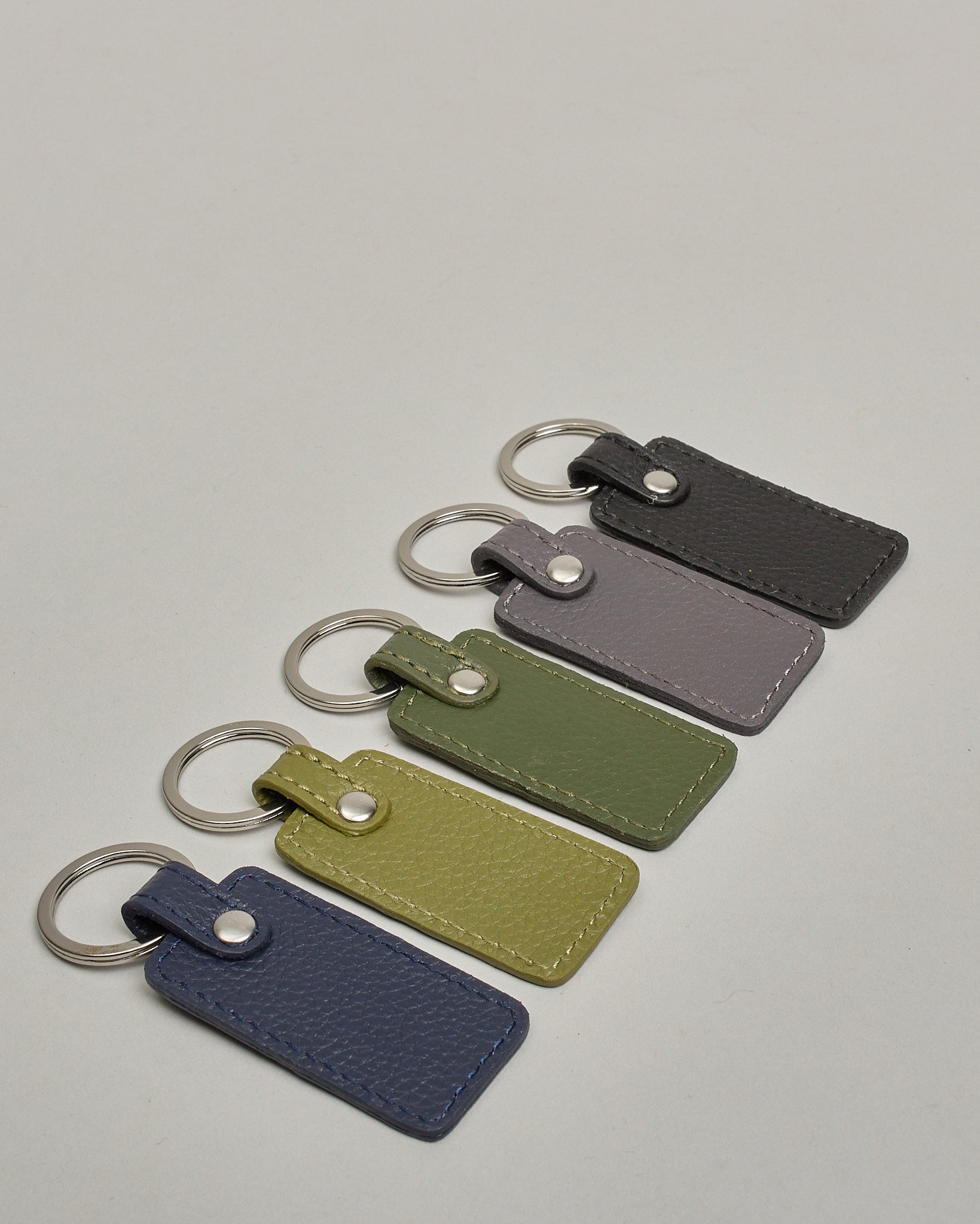 Schlüsselanhänger in Rechteckiger Form aus echtem Rindsleder. Das Leder ist grün, der Ring mit dem man das Lederaccessoire an dem Schlüssel befestigen kann ist silber. Auf der Rückseite ist die das Logo "Herzilein Wien" eingeprägt. Die Vorderseite kann personalisiert werden