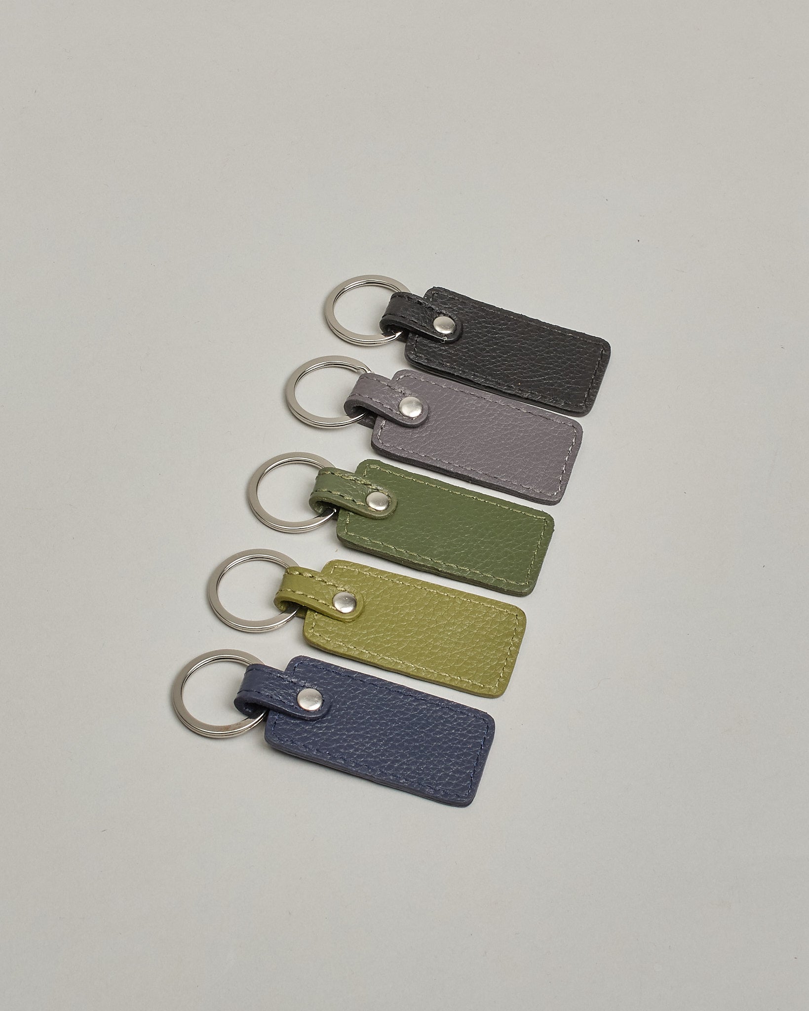 Schlüsselanhänger in Rechteckiger Form aus echtem Rindsleder. Das Leder ist grün, der Ring mit dem man das Lederaccessoire an dem Schlüssel befestigen kann ist silber. Auf der Rückseite ist die das Logo "Herzilein Wien" eingeprägt. Die Vorderseite kann personalisiert werden