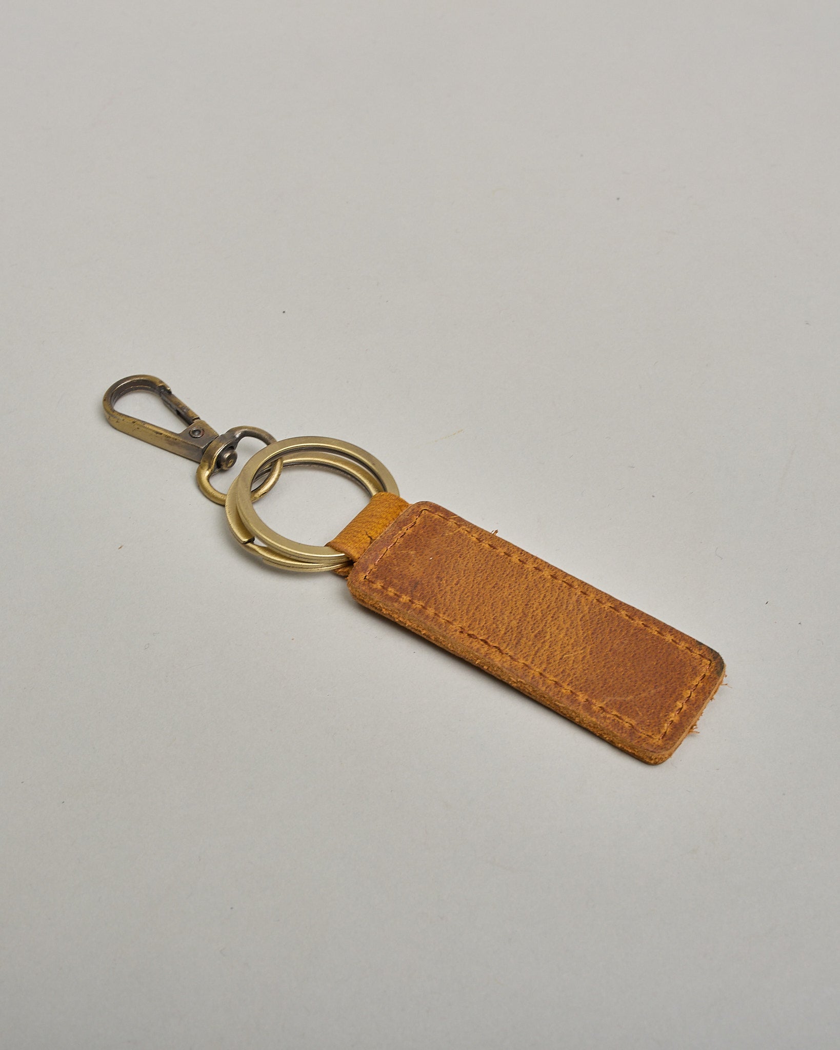 Schlüsselanhänger in Rechteckiger Form aus echtem Rindsleder. Das Leder ist dunklebraun, der Ring mit dem man das Lederaccessoire an dem Schlüssel befestigen kann ist antik.