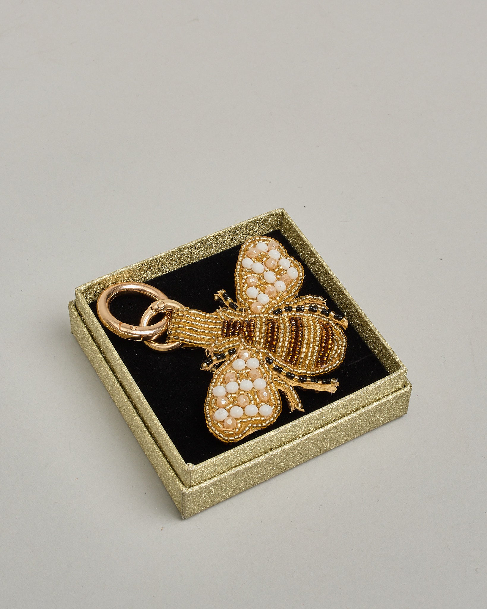 Schlüsselanhänger mit handgemachter Perlenstickerei in Form einer Biene. Die Perlenfarben sind beige, braun, weiß und schwarz. #2