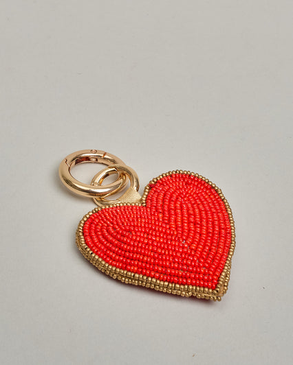 Schlüsselanhänger mit handgemachter Perlenstickerei in Form eines Herzen. Innen ist es rot und hat einen dezenten goldenen Rand. #1