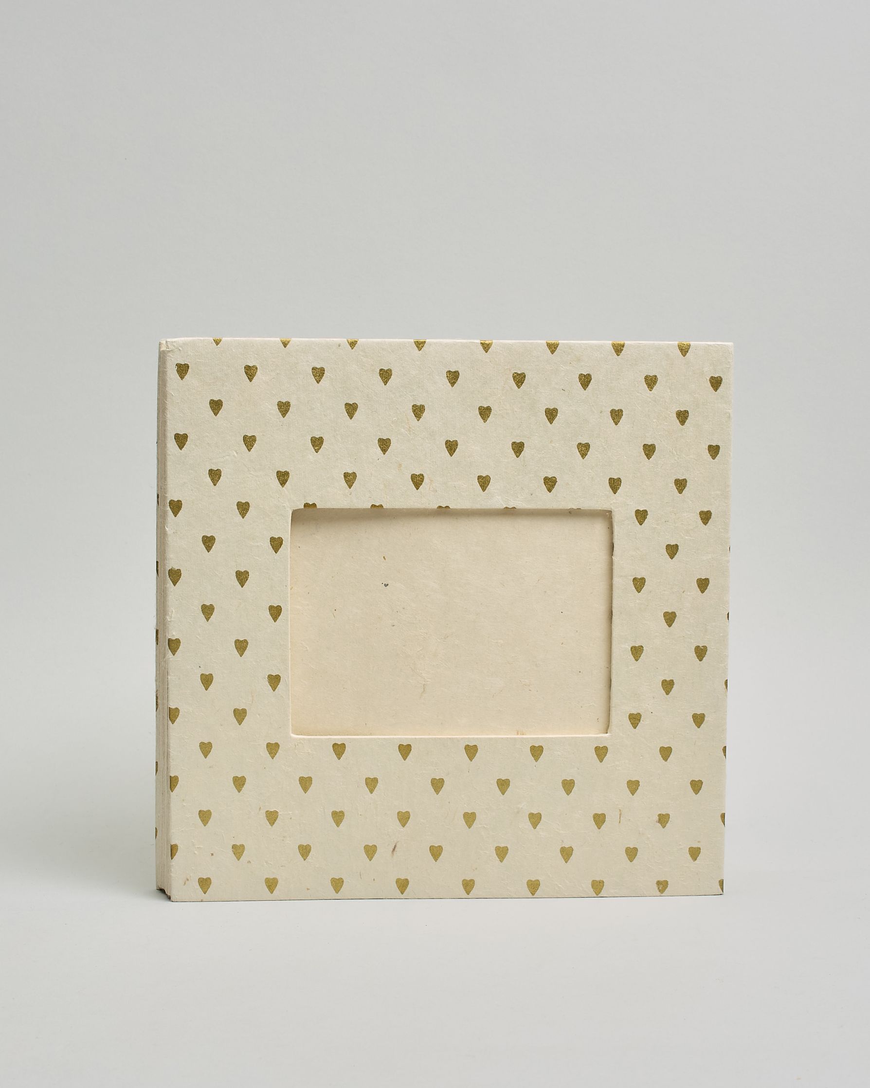 Ein Quadratisches Fotoalbum oder Gästebuch mit Hardcover in naturweißer Grundfarbe und darauf goldene kleine Herzen, die über das ganze Cover verteilt sind. In der Mitte befindet sich ein rechteckeiges Fenster hinter dem man ein Einlageblatt mit kalligrafiertem Text befestigen kann. #2