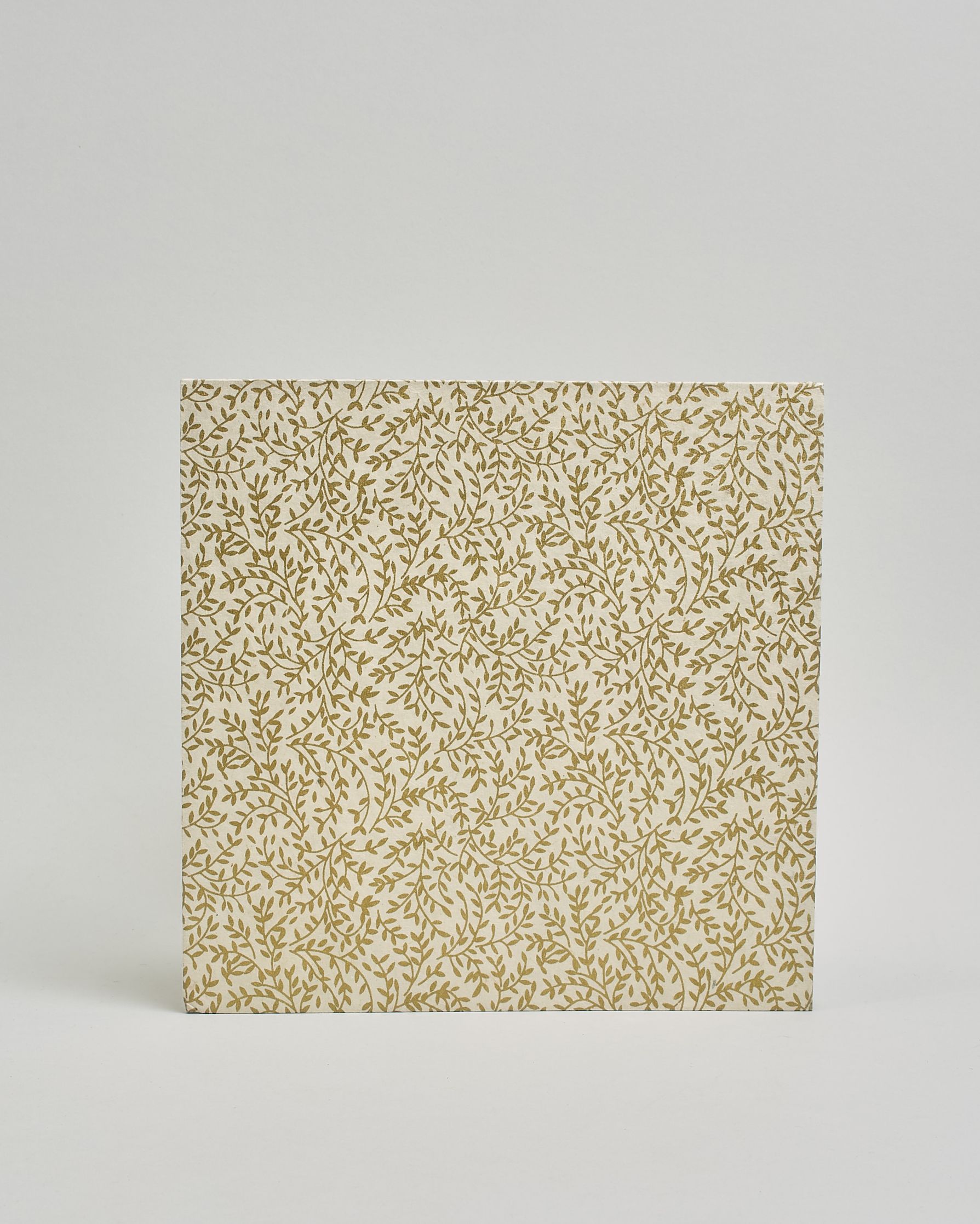 Ein Quadratisches Fotoalbum oder Gästebuch mit Hardcover in naturweißer Grundfarbe und darauf goldene Zweigen mit Blättern daran, die über das ganze Cover verteilt sind. In der Mitte befindet sich ein rechteckeiges Fenster hinter dem man ein Einlageblatt mit kalligrafiertem Text befestigen kann. #3