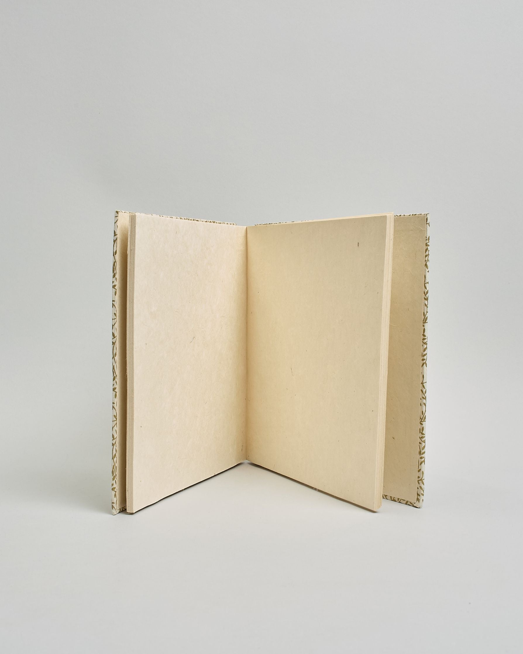 Ein Quadratisches Fotoalbum oder Gästebuch mit Hardcover in naturweißer Grundfarbe und darauf goldene Zweigen mit Blättern daran, die über das ganze Cover verteilt sind. In der Mitte befindet sich ein rechteckeiges Fenster hinter dem man ein Einlageblatt mit kalligrafiertem Text befestigen kann. #4