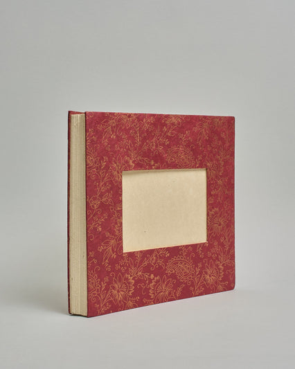 Ein Quadratisches Fotoalbum oder Gästebuch mit Hardcover in bordeauxroter Grundfarbe, darauf befindet sich ein großes Blumenmuster, die über das ganze Cover verteilt sind. In der Mitte befindet sich ein rechteckeiges Fenster hinter dem man ein Einlageblatt mit kalligrafiertem Text befestigen kann. #1