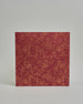 Ein Quadratisches Fotoalbum oder Gästebuch mit Hardcover in bordeauxroter Grundfarbe, darauf befindet sich ein großes Blumenmuster, die über das ganze Cover verteilt sind. In der Mitte befindet sich ein rechteckeiges Fenster hinter dem man ein Einlageblatt mit kalligrafiertem Text befestigen kann. #3