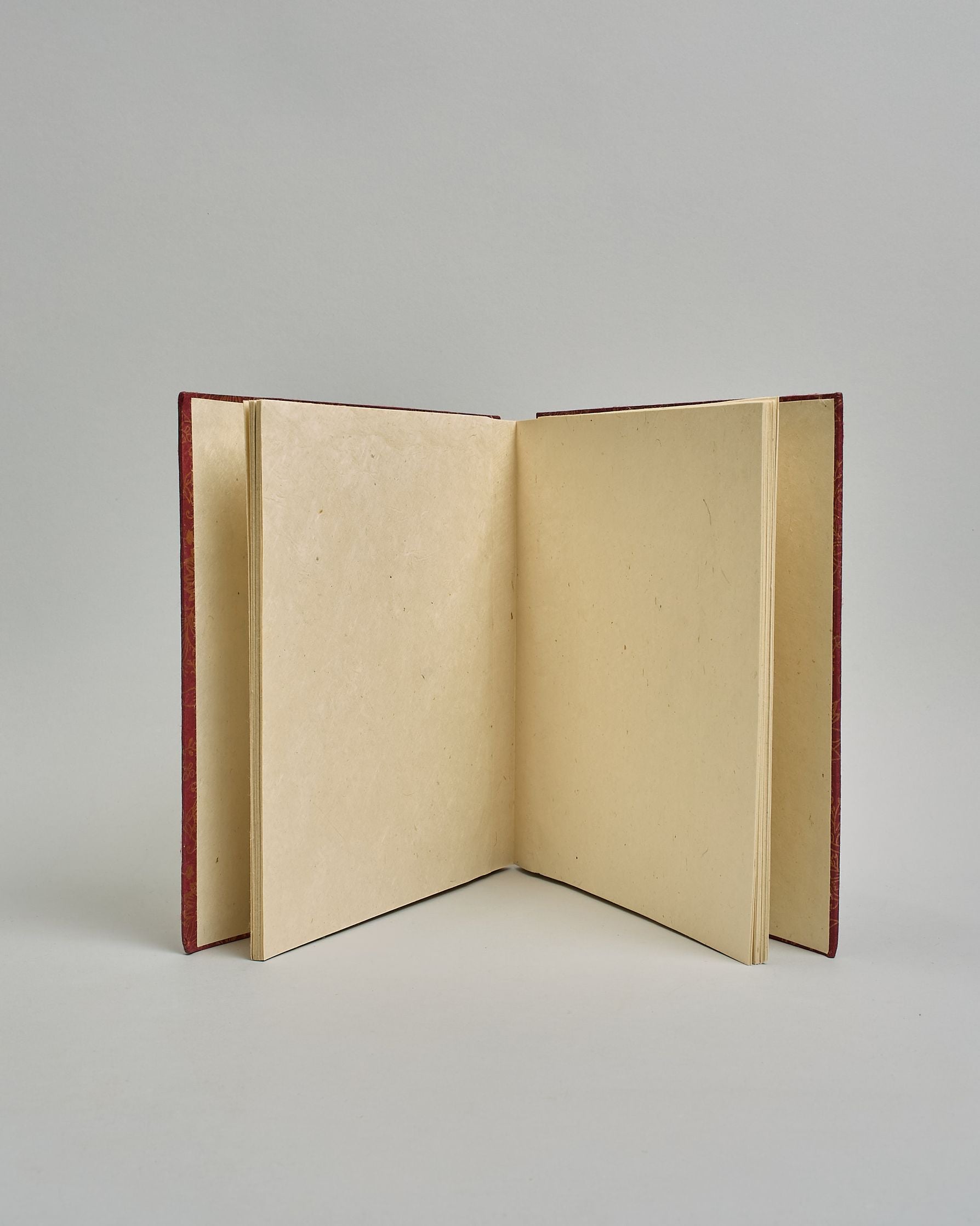 Ein Quadratisches Fotoalbum oder Gästebuch mit Hardcover in bordeauxroter Grundfarbe, darauf befindet sich ein großes Blumenmuster, die über das ganze Cover verteilt sind. In der Mitte befindet sich ein rechteckeiges Fenster hinter dem man ein Einlageblatt mit kalligrafiertem Text befestigen kann. #4