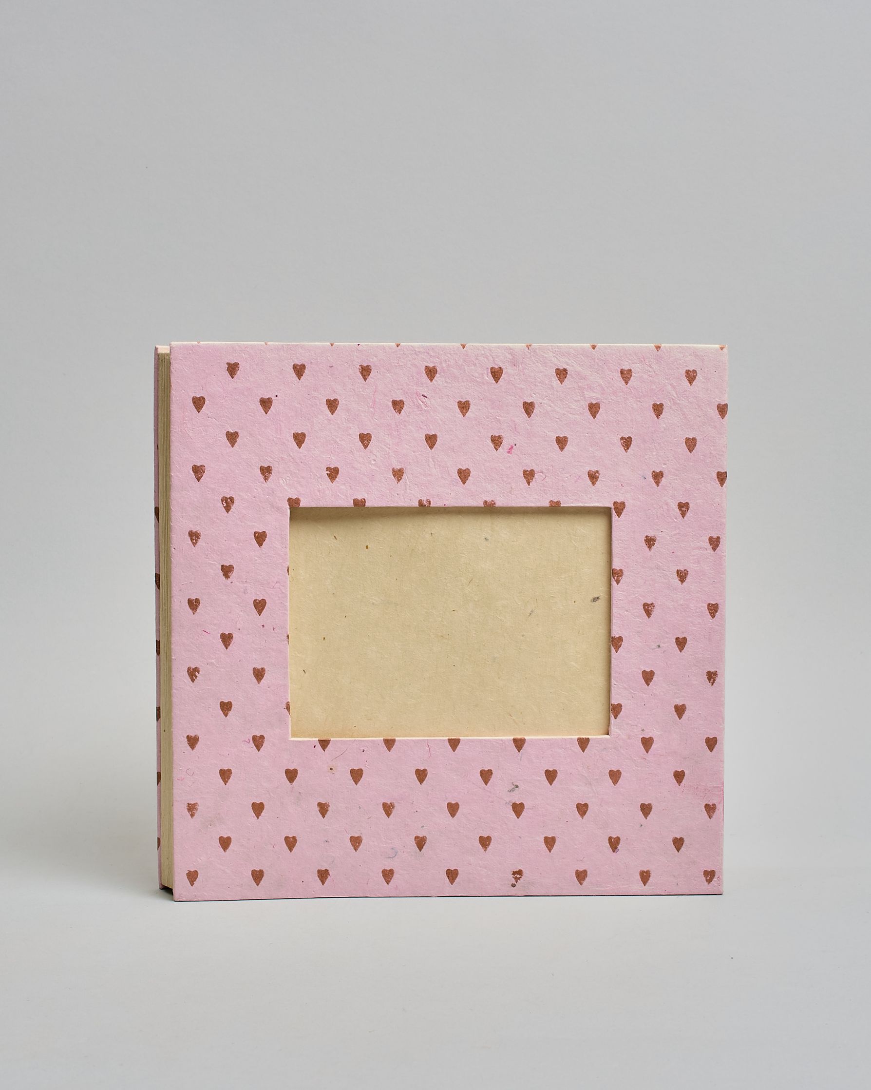 Ein Quadratisches Fotoalbum oder Gästebuch mit Hardcover in rosaner Grundfarbe und darauf roséfarbene kleinen Herzen, die über das ganze Cover verteilt sind. In der Mitte befindet sich ein rechteckeiges Fenster hinter dem man ein Einlageblatt mit kalligrafiertem Text befestigen kann. #2