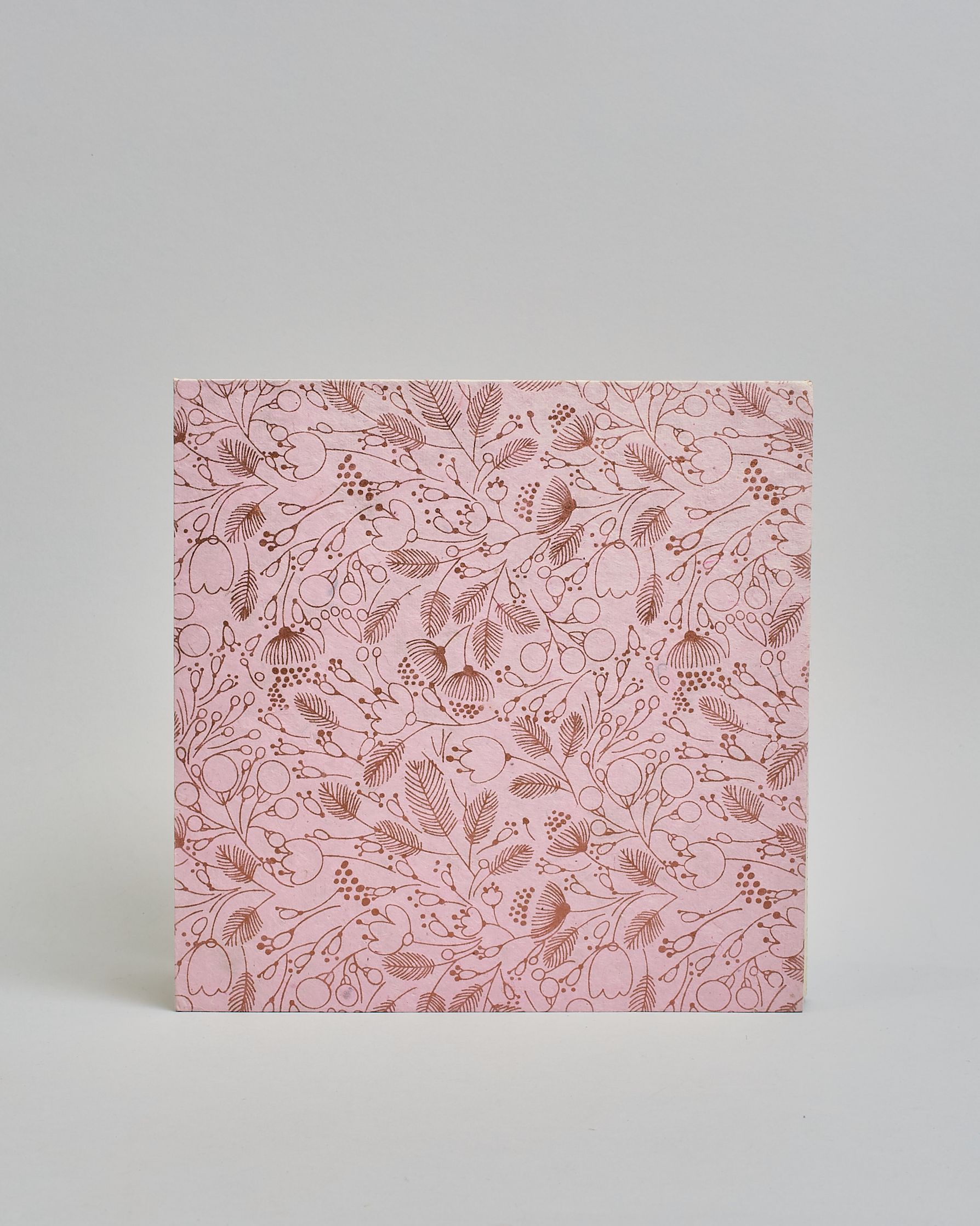 Ein Quadratisches Fotoalbum oder Gästebuch mit Hardcover in rosaner Grundfarbe und darauf roséfarbene Blüten, die über das ganze Cover verteilt sind. In der Mitte befindet sich ein rechteckeiges Fenster hinter dem man ein Einlageblatt mit kalligrafiertem Text befestigen kann. #3