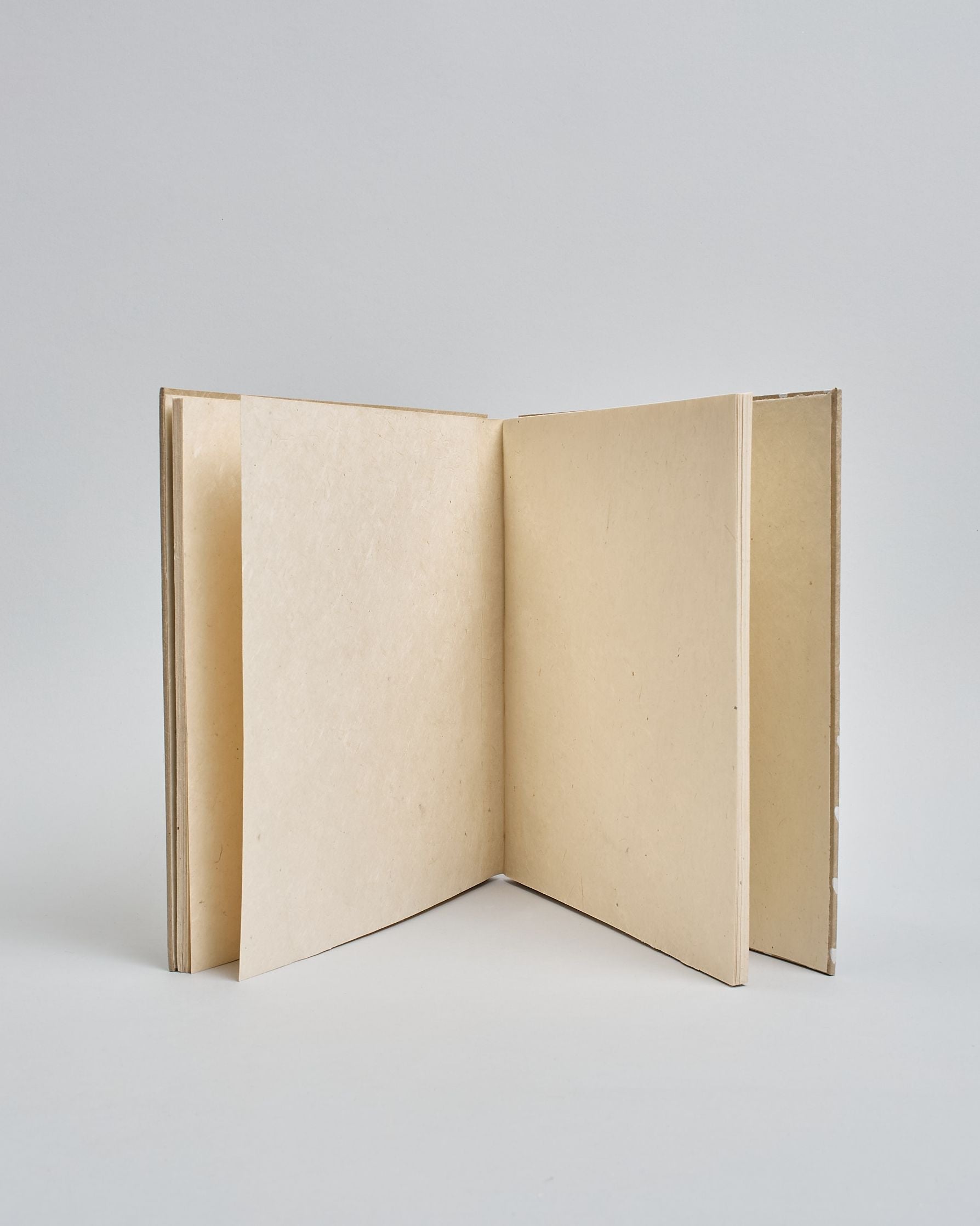 Ein Quadratisches Fotoalbum oder Gästebuch mit Hardcover in beiger Grundfarbe und darauf weiße Herzen, die über das ganze Cover verteilt sind. In der Mitte befindet sich ein rechteckeiges Fenster hinter dem man ein Einlageblatt mit kalligrafiertem Text befestigen kann. #4