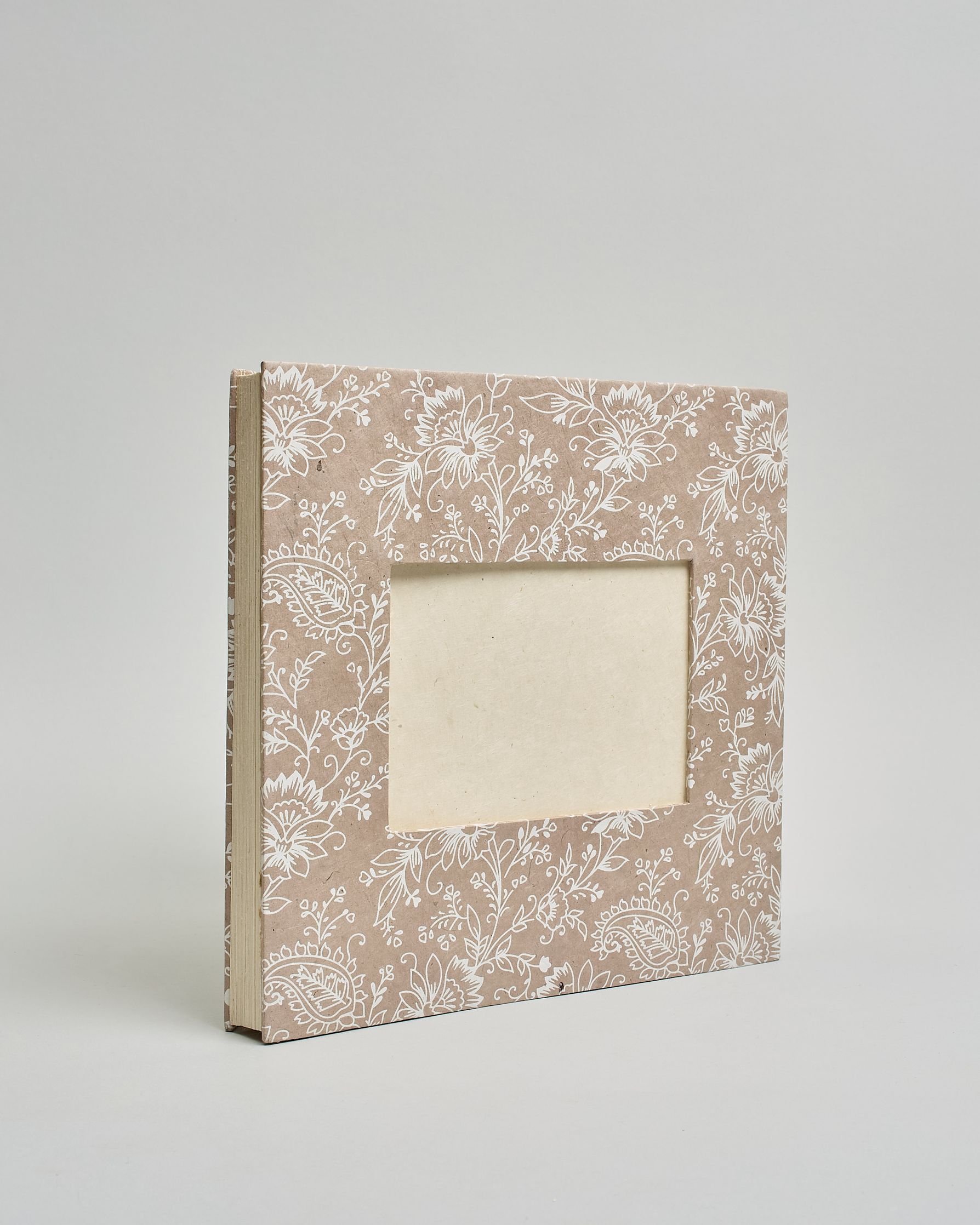 Ein Quadratisches Fotoalbum oder Gästebuch mit Hardcover in beiger Grundfarbe und darauf weiße Blumen, die über das ganze Cover verteilt sind. In der Mitte befindet sich ein rechteckeiges Fenster hinter dem man ein Einlageblatt mit kalligrafiertem Text befestigen kann. #2