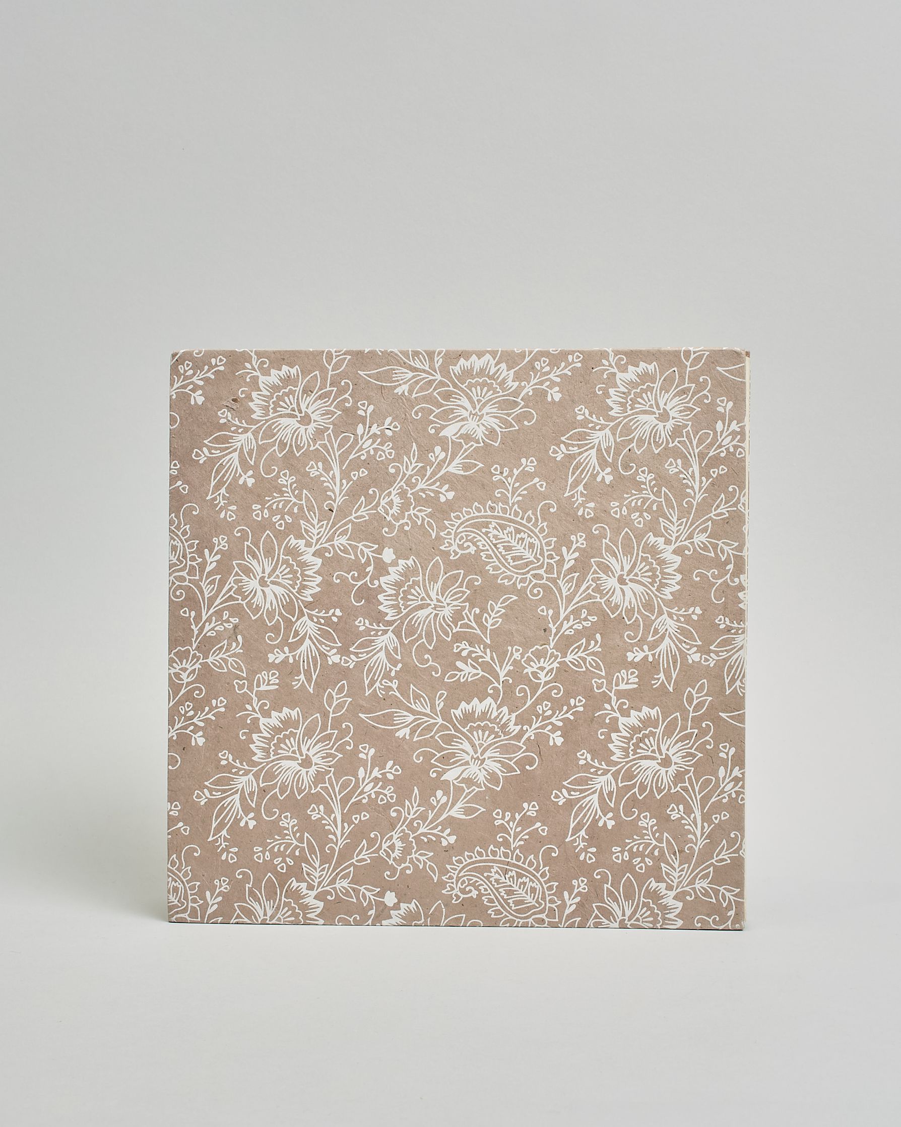 Ein Quadratisches Fotoalbum oder Gästebuch mit Hardcover in beiger Grundfarbe und darauf weiße Blumen, die über das ganze Cover verteilt sind. In der Mitte befindet sich ein rechteckeiges Fenster hinter dem man ein Einlageblatt mit kalligrafiertem Text befestigen kann. #4