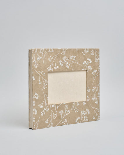 Ein Quadratisches Fotoalbum oder Gästebuch mit Hardcover in beiger Grundfarbe und darauf weiße Äste, die über das ganze Cover verteilt sind. In der Mitte befindet sich ein rechteckeiges Fenster hinter dem man ein Einlageblatt mit kalligrafiertem Text befestigen kann. #1