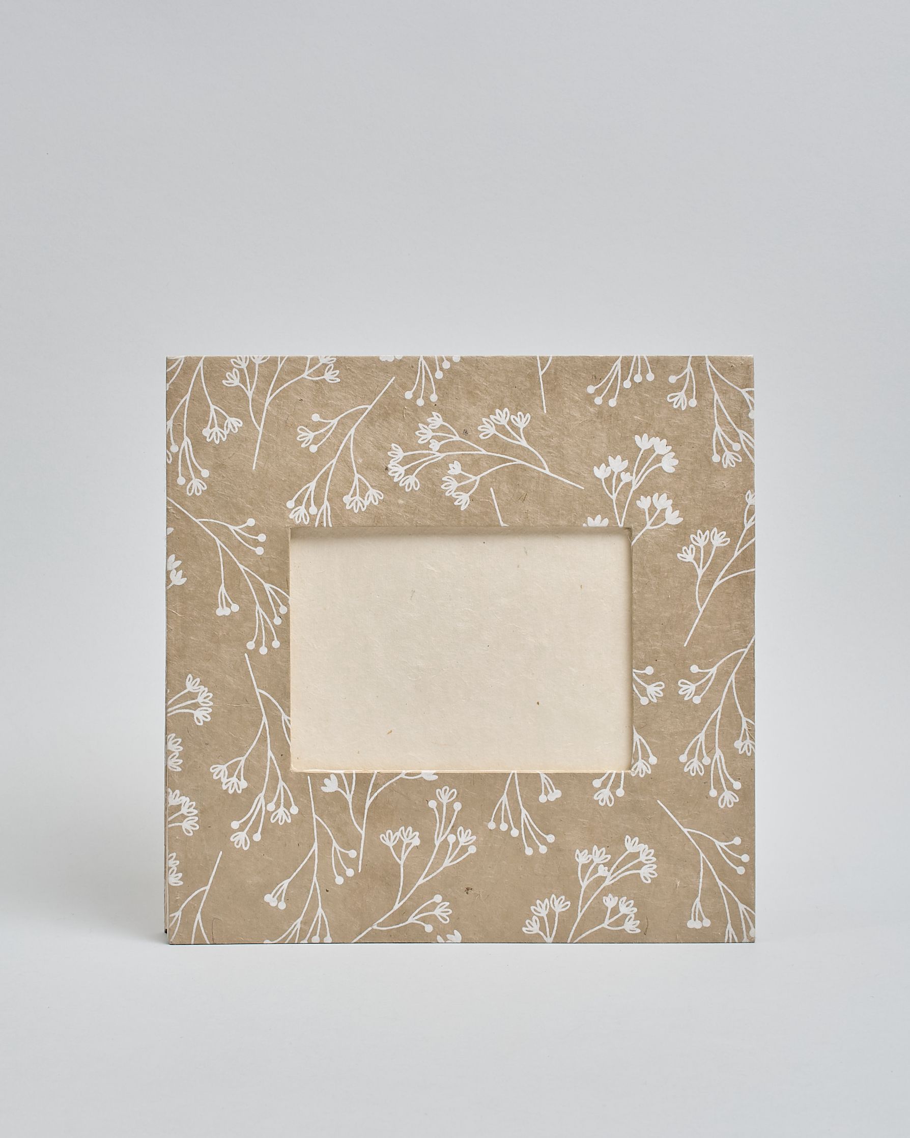 Ein Quadratisches Fotoalbum oder Gästebuch mit Hardcover in beiger Grundfarbe und darauf weiße Äste, die über das ganze Cover verteilt sind. In der Mitte befindet sich ein rechteckeiges Fenster hinter dem man ein Einlageblatt mit kalligrafiertem Text befestigen kann. #2