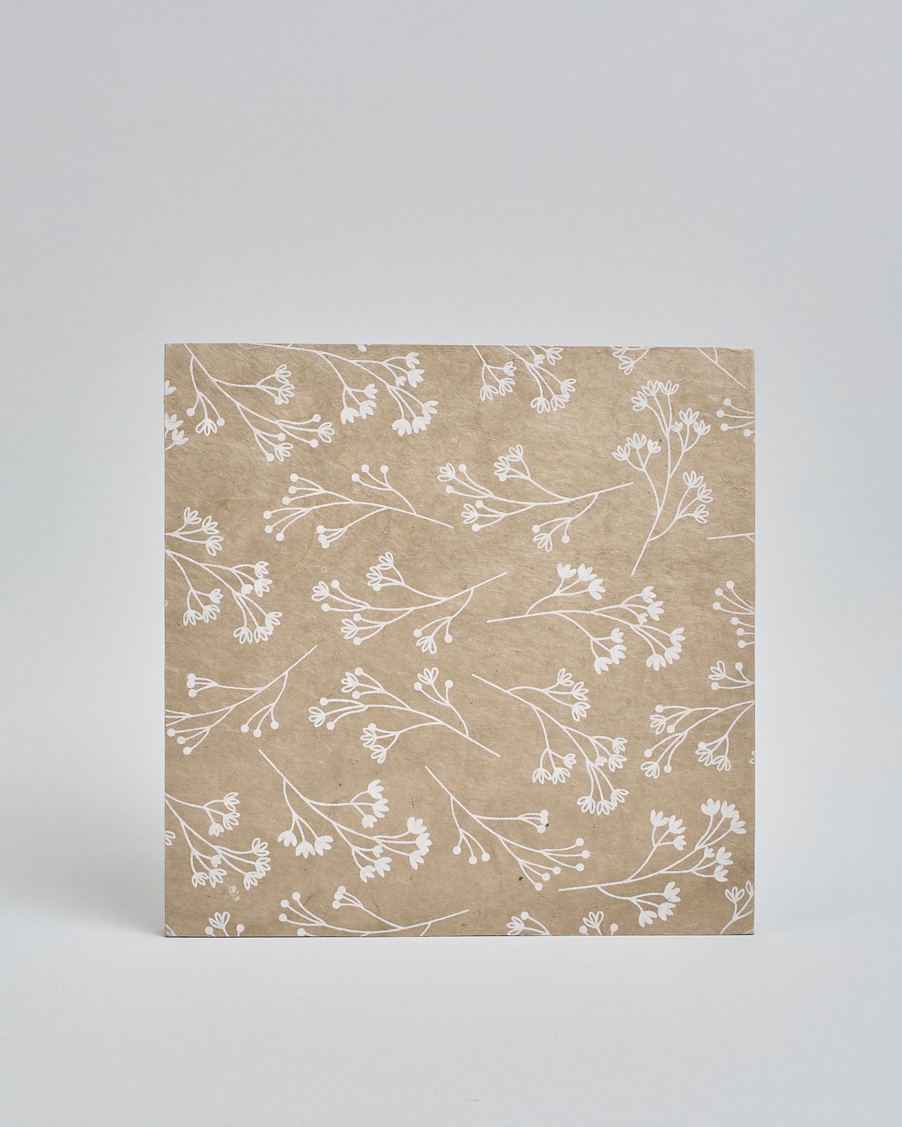 Ein Quadratisches Fotoalbum oder Gästebuch mit Hardcover in beiger Grundfarbe und darauf weiße Äste, die über das ganze Cover verteilt sind. In der Mitte befindet sich ein rechteckeiges Fenster hinter dem man ein Einlageblatt mit kalligrafiertem Text befestigen kann. #3