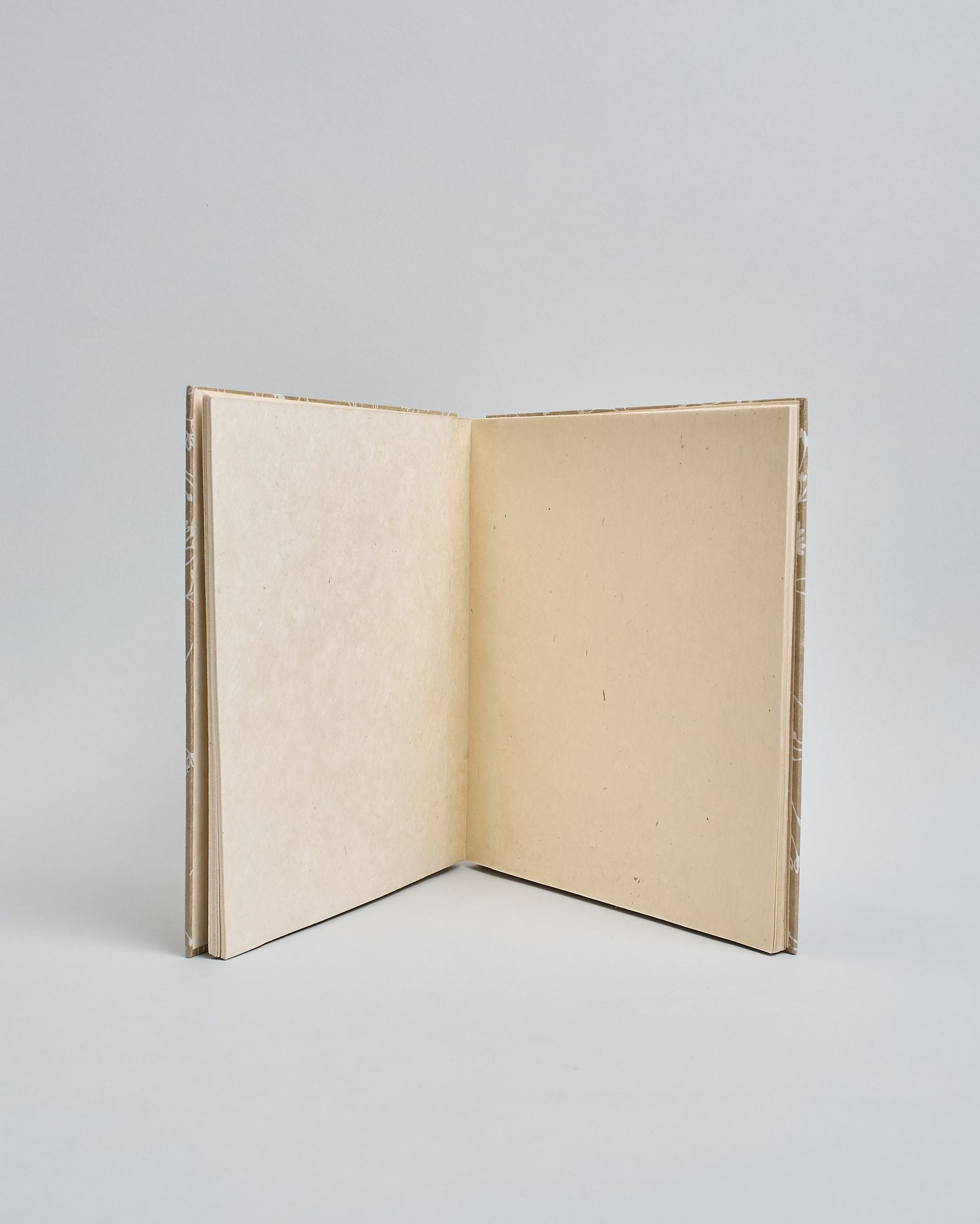 Ein Quadratisches Fotoalbum oder Gästebuch mit Hardcover in beiger Grundfarbe und darauf weiße Äste, die über das ganze Cover verteilt sind. In der Mitte befindet sich ein rechteckeiges Fenster hinter dem man ein Einlageblatt mit kalligrafiertem Text befestigen kann. #4
