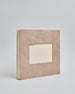 Ein Quadratisches Fotoalbum oder Gästebuch mit Hardcover in naturfarbener, weißer Grundfarbe, in der Mitte befindet sich ein rechteckeiges Fenster hinter dem man ein Einlageblatt mit kalligrafiertem Text befestigen kann. #1