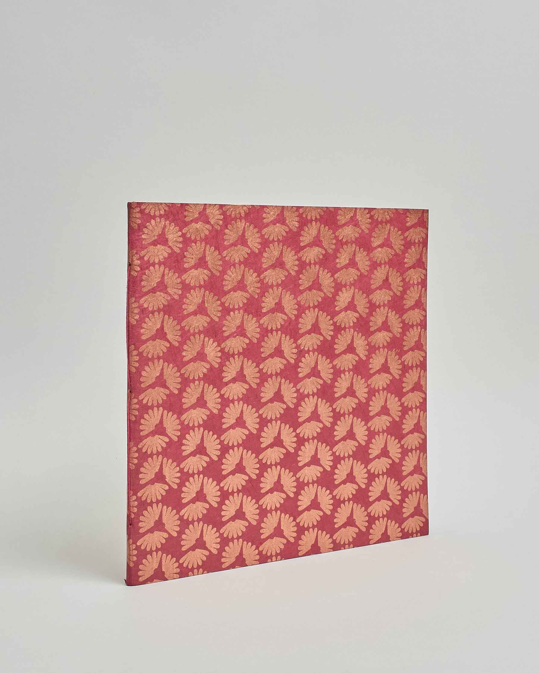 Ein Quadratisches Fotoalbum oder Gästebuch mit Softcover in hellrosaner Grundfarbe und darauf roséfarbene kleine Herzen, die über das ganze Cover verteilt sind. #1