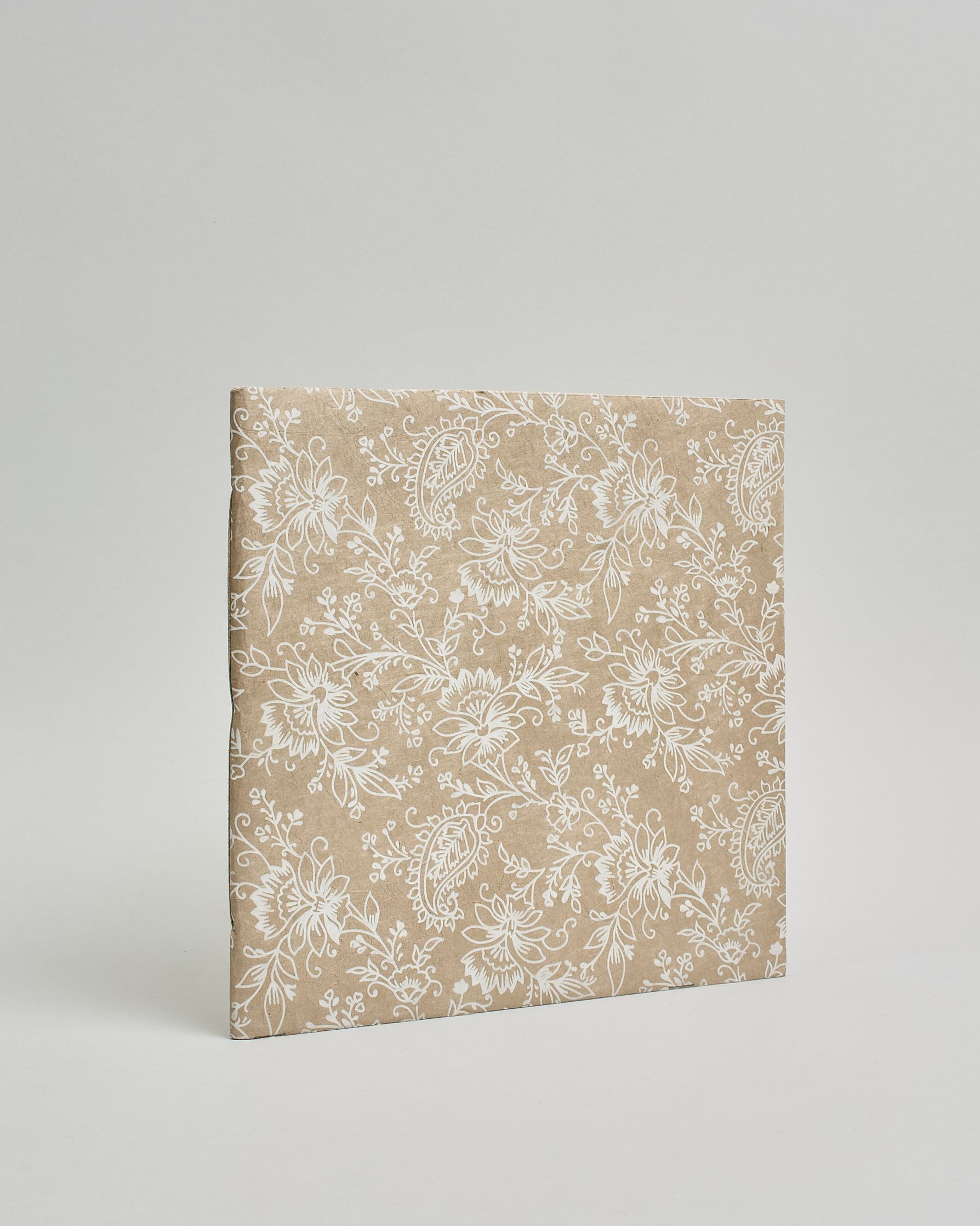 Ein Quadratisches Fotoalbum oder Gästebuch mit Softcover in beiger Grundfarbe und darauf weiße Blumen, die über das ganze Cover verteilt sind. #1