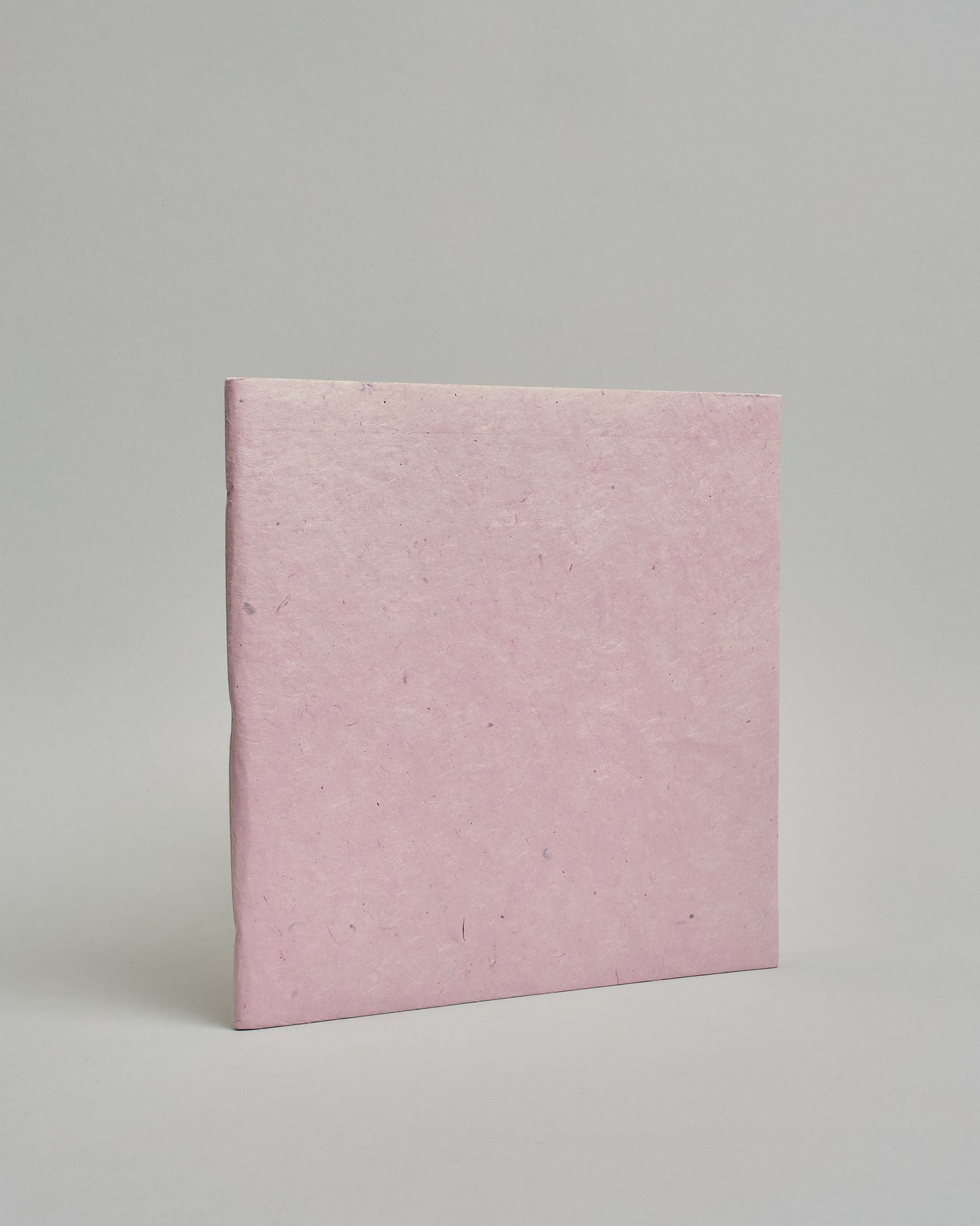 Ein Quadratisches Fotoalbum oder Gästebuch mit Softcover einfärbig in hellrosa.