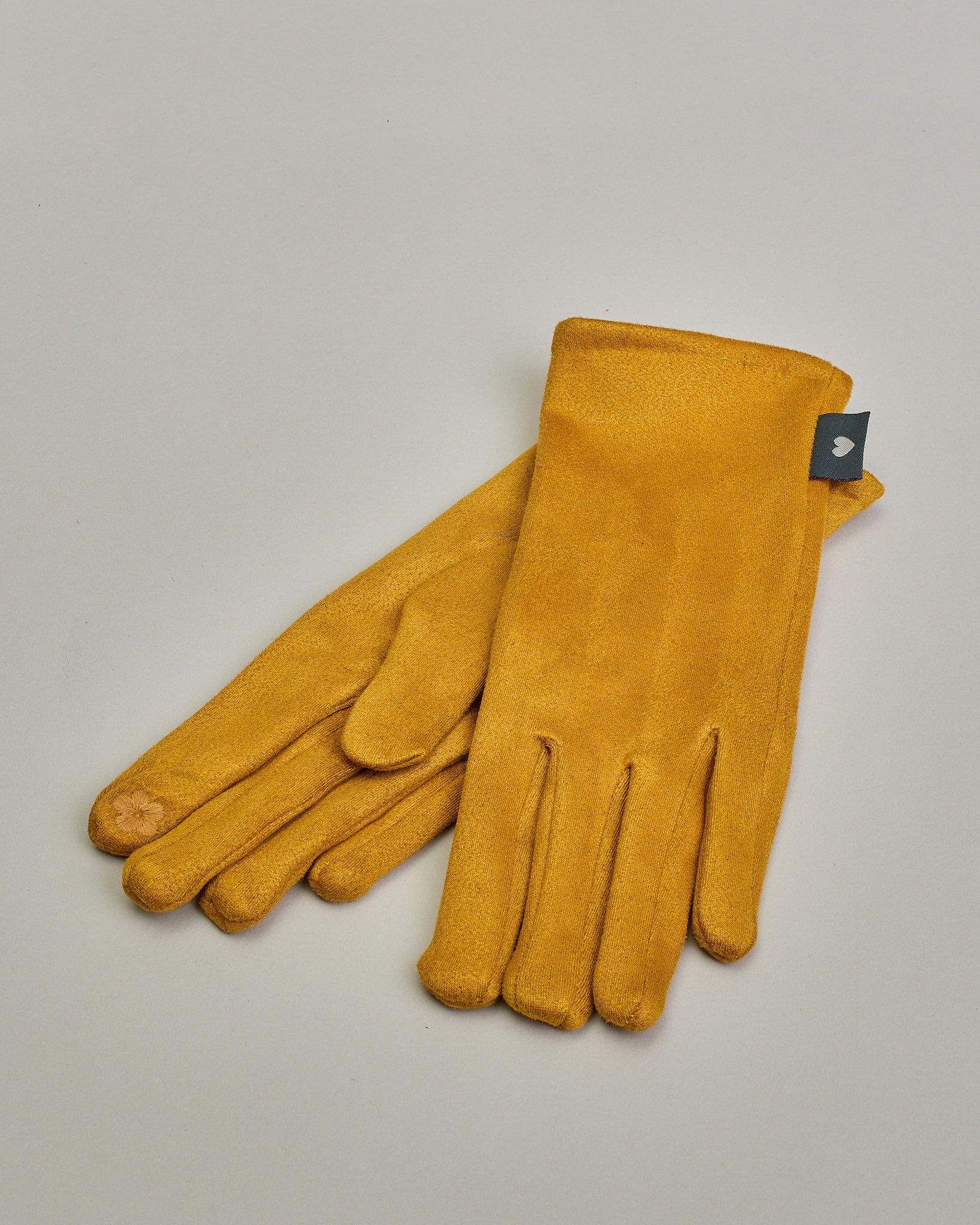 Pinke Handschuhe in Velourlederoptik mit eingestickter Blume auf dem Daumen und Zeigefinger als Bedienungshife für das Handy.