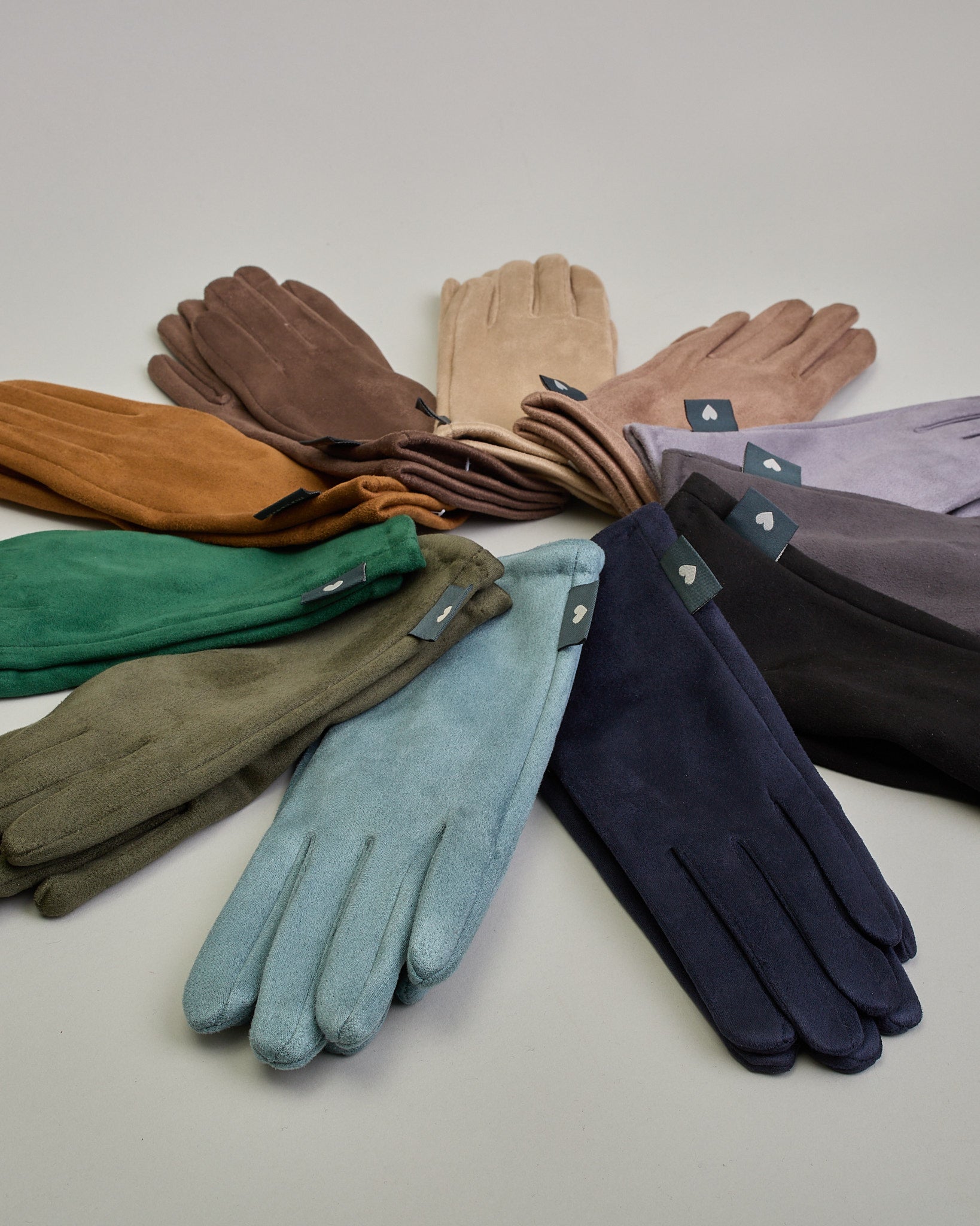 Senfgelbe Handschuhe in Velourlederoptik mit eingestickter Blume auf dem Daumen und Zeigefinger als Bedienungshife für das Handy.