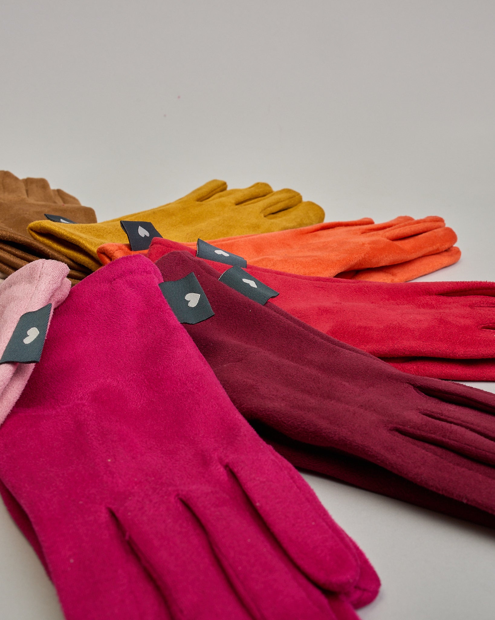 Senfgelbe Handschuhe in Velourlederoptik mit eingestickter Blume auf dem Daumen und Zeigefinger als Bedienungshife für das Handy.