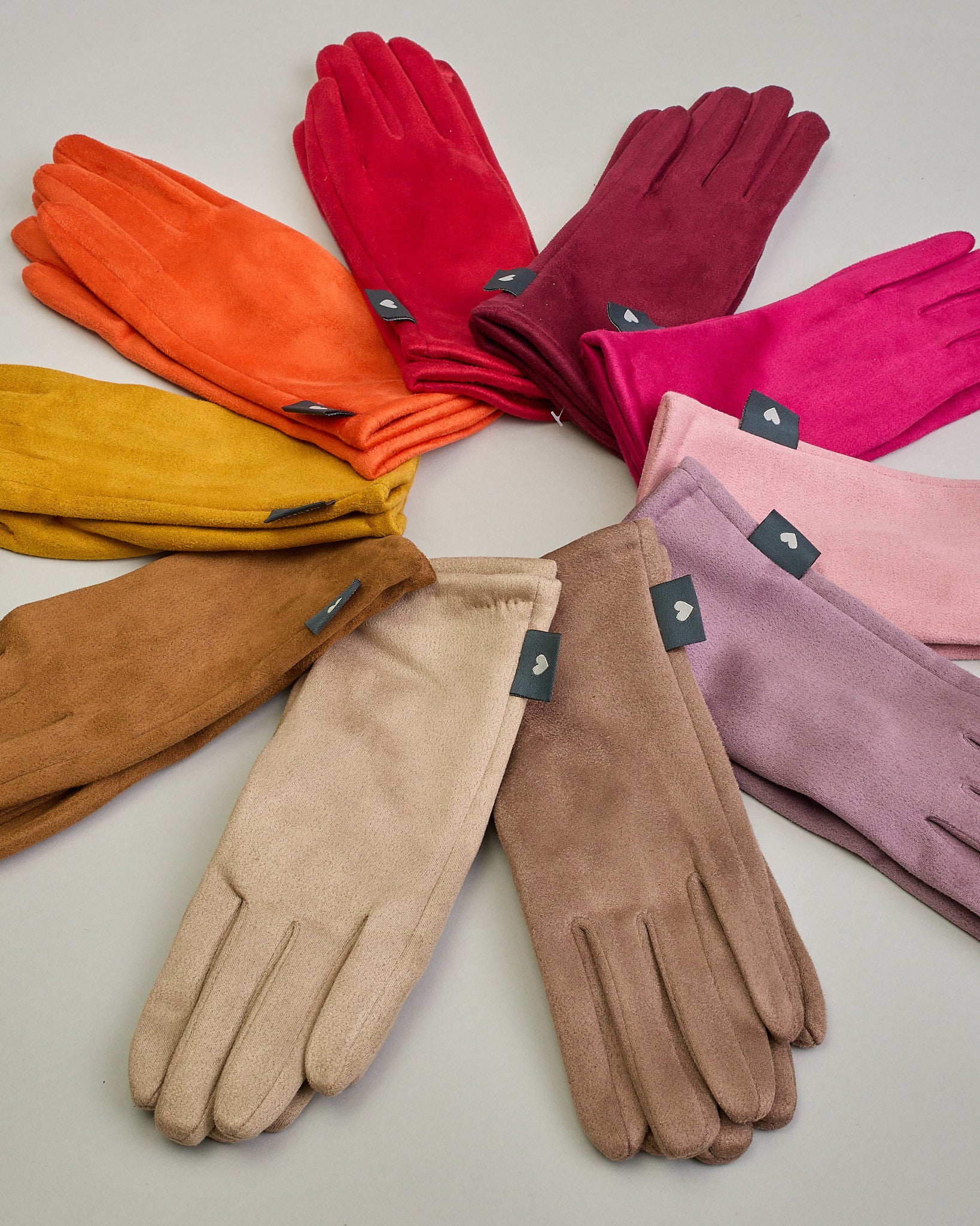 Senfgelbe Handschuhe in Velourlederoptik mit eingestickter Blume auf dem Daumen und Zeigefinger als Bedienungshife für das Handy.