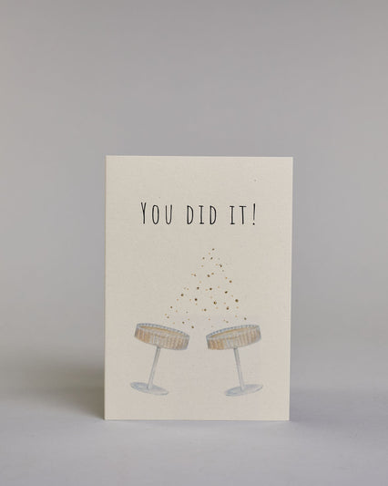 Glückwunschkarte zu einem allgemeinen Erfolg oder zu einer Hochzeit in Englisch mit schwarzer Kalligrafieaufschrift  ‚You did it!‘,  darunter zwei gezeichnete Champagnergläser die anstoßen, zwischen dem Text und den Gläsern sind vergoldete Pünktchen auf hellem Hintergrund. Dazu ein weißes handgeschöpftes Kuvert. #1