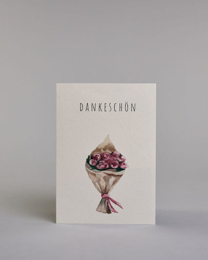 Dankeskarte mit dünner, gerader, schwarzer Kalligrafieaufschrift  ‚DANKESCHÖN‘,  darunter ein gezeichneter Blumenstrauß auf hellem Hintergrund. Dazu ein weißes handgeschöpftes Kuvert. #1