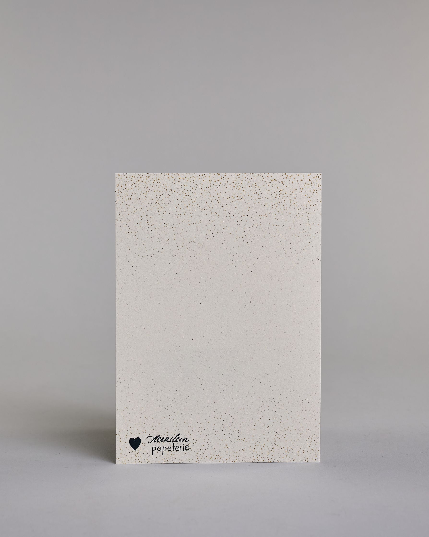 Karte in Englisch mit goldener Kalligrafieaufschrift ‚surprise surprise‘, von der oberen und unteren Kartenkante kommt ein Pünktchenregen auf hellem Hintergrund. Dazu ein weißes handgeschöpftes Kuvert. #4