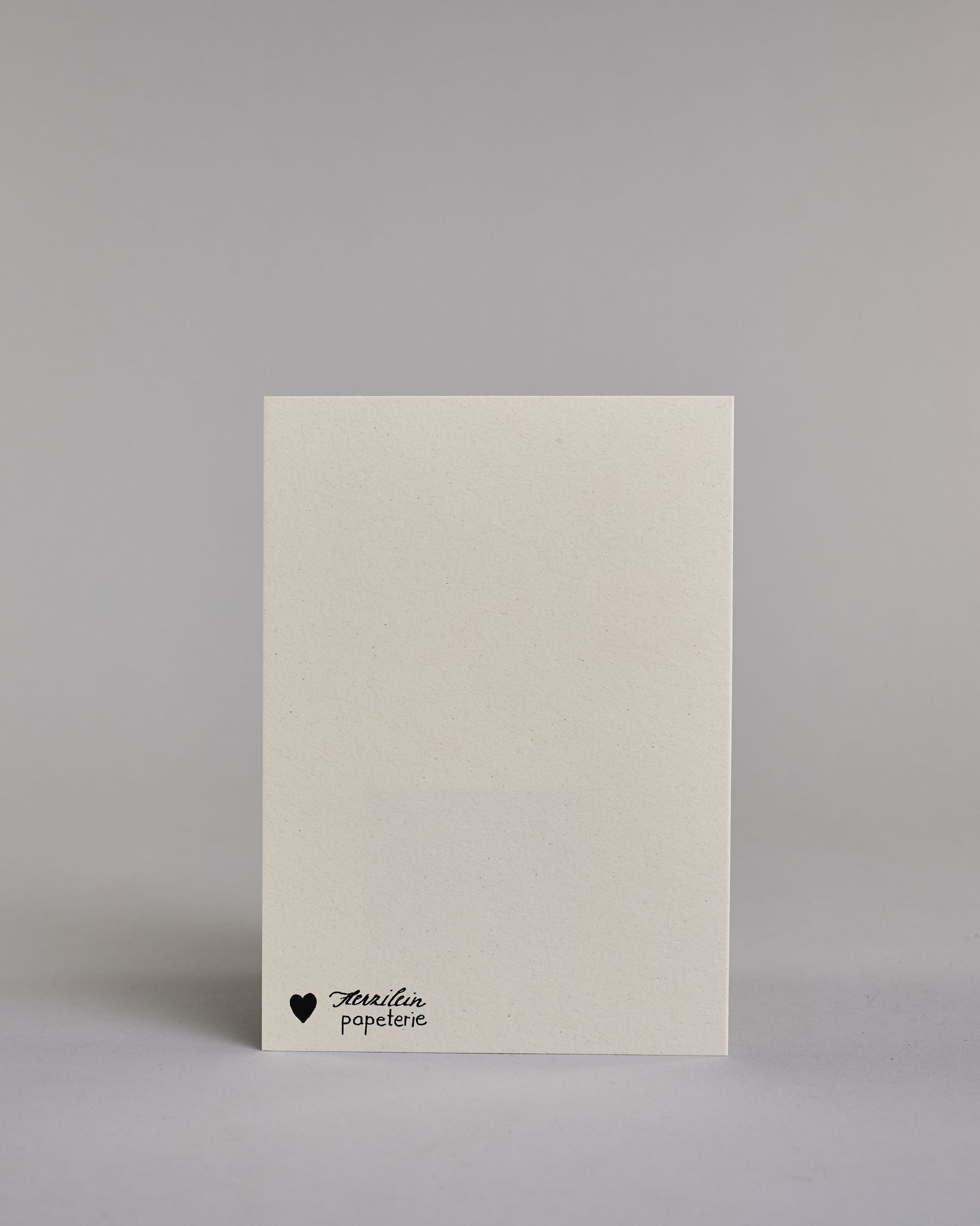 Glückwunschkarte zur Geburt mit der Aufschrift „Willkommen auf der Welt“ in schwarzer Handlettering-Schrift. Darunter ist ein bunter Regenbogen in Aquarelloptik mit den Farben Rot, Orange, Gelb, Grün, Blau und Lila abgebildet. Dazu ein beige-weißes handgeschöpftes Kuvert. #4