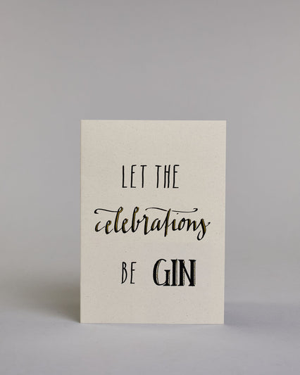 Karte in Englisch mit der Aufschrift „Let the celebrations be gin“ in schwarzer Handlettering-Schrift, wobei die Wörter „celebrations“ und „GIN“ mit goldfarbenen Akzenten hervorgehoben sind. Das "celebrations" steht in der mittleren der drei Zeilen und ist in geschwungener Kalligrafieaufschrift gemacht, während die Zeile darüber und darunter mit dem "LET THE" und "BE GIN"  in gerade Schrift auf hellem Hintergrund sind. Dazu ein grün-goldenes handgeschöpftes Kuvert. #1