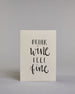Karte in Englisch mit der Aufschrift „Drink wine feel fine“ in schwarzer Handlettering-Schrift, teils mit kleinen goldfarbenen Akzenten auf vier Zeilen mit jeweils immer einem Wort aufgeteilt und auf hellem Hintergrund. Dazu ein grün-goldenes handgeschöpftes Kuvert. #1