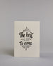 Karte in Englisch mit der Aufschrift „The best is yet to come“ in schwarzer Handlettering-Schrift, teilweise mit goldfarbenen Akzenten hervorgehoben. Über und unter dem Text sind kleine stilisierte, ebenfalls verglitzerte Feuerwerksmotive abgebildet. Dazu ein weiß-goldenes handgeschöpftes Kuvert. #1