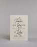 Karte mit der Aufschrift „Familie wo das Leben beginnt & die Liebe niemals endet!“ in schwarzer Handlettering-Schrift auf hellem Hintergrund. Feine Linienornamente rahmen den Text dekorativ ein. Das Design ist schlicht und elegant. Herausgehoben sind die Wörter "Familie", "Leben" und "Liebe". Dazu ein grün-goldenes handgeschöpftes Kuvert. #1