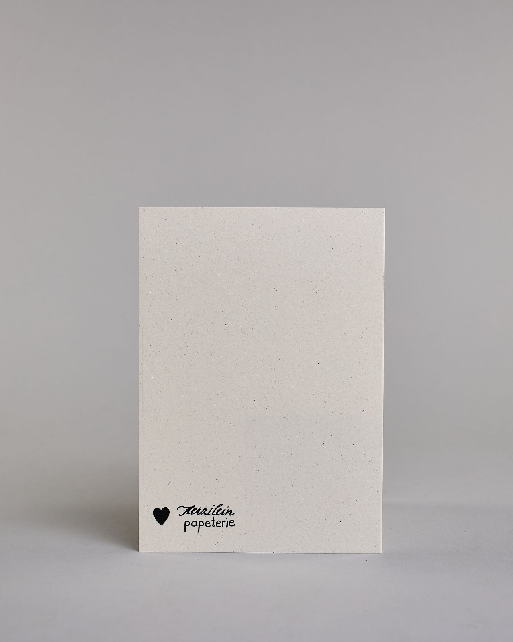 Gutschein-Karte mit einem gezeichneten Blumenstrauß aus filigranen Blüten und Zweigen, zusammengebunden mit einer goldfarbenen Schleife. Um den Strauß verläuft ein Herzkranz. Rechts neben dem Strauß steht das Wort „Gutschein“ in schwarzer Schrift in den Kranz eingearbeitet auf hellem Hintergrund. Dazu ein grün-goldenes handgeschöpftes Kuvert. #4