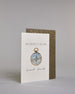 Karte mit der Aufschrift „Adventure is calling Good luck“ in schwarzer Kalligrafieaufschrift. In der Mitte ist eine detailreich gezeichnete Kompass-Illustration mit goldenem Rand und goldener Nadel abgebildet, die Innenseite des Kompasses ist hellblau und die Karte selbst bildet einen hellen Hintergrund. Dazu ein grün-goldenes handgeschöpftes Kuvert. #3