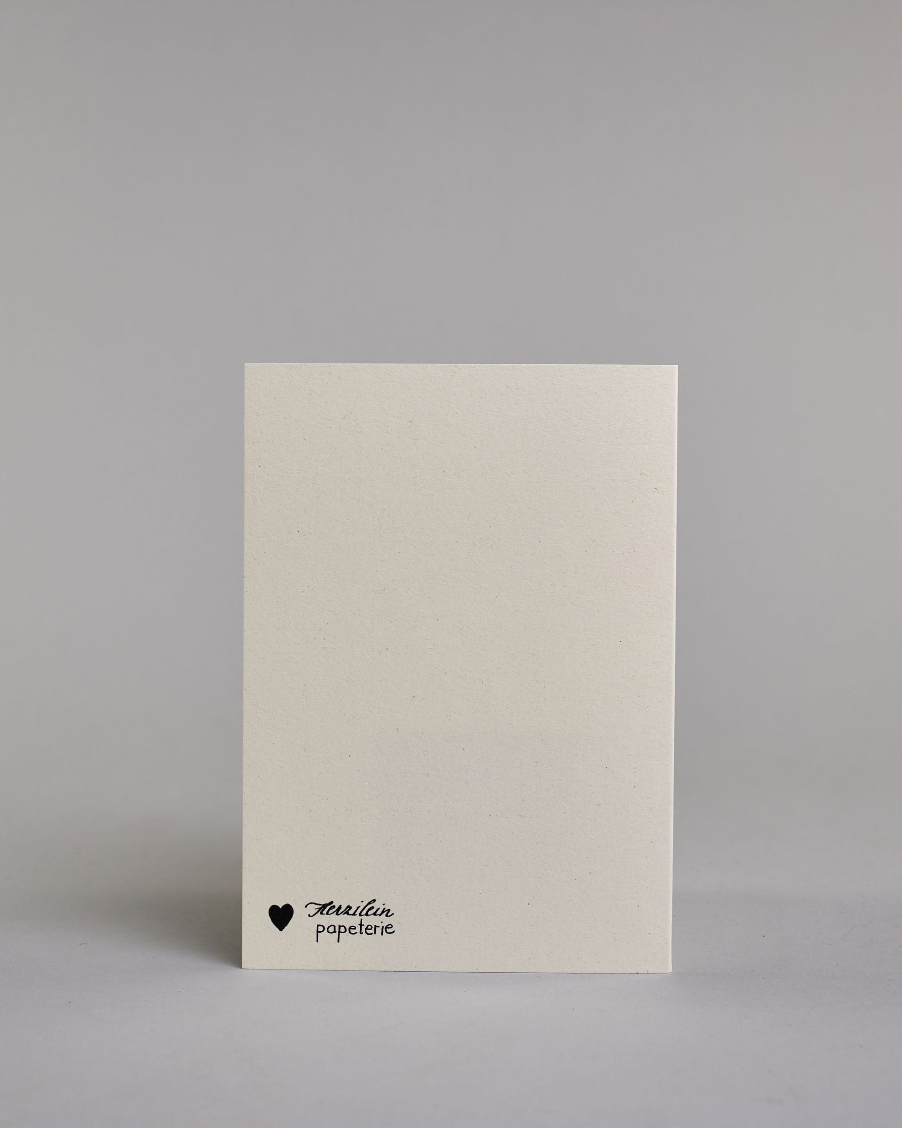 Gutschein-Karte mit der schlichten Aufschrift „Gutschein“ in schwarzer Schrift auf hellem Hintergrund. Darunter ist ein stilisierter Blumenstrauß in gedeckten Rosa-, Rot- und Grüntönen abgebildet, zusammengebunden mit einer schwarzen Schleife.Dazu ein grün-goldenes handgeschöpftes Kuvert. #4