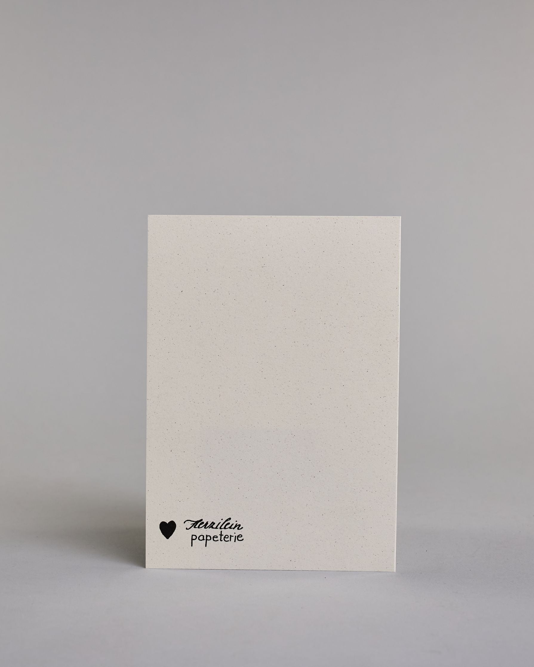 Glückwunschkarte zum Geburtstag mit schwarzer Kalligrafieaufschrift "...das ist doch kein Alter! Glückwunsch". Der Text ist auf vier Zeilen aufgeteilt, welche wiefolge gegliedert sind: "...das ist" in dünner Schreibschrift, darunter "doch kein" in dünner Schreibschrift, darunter "Alter!" in breiterer Schreibschrift und mit Goldakzenten, darunter "GLÜCKWUNSCH" in dünner gerader Kalligrafieschrift. Alles ist auf hellem Hintergrund. Dazu ein grün-goldenes handgeschöpftes Kuvert. #4